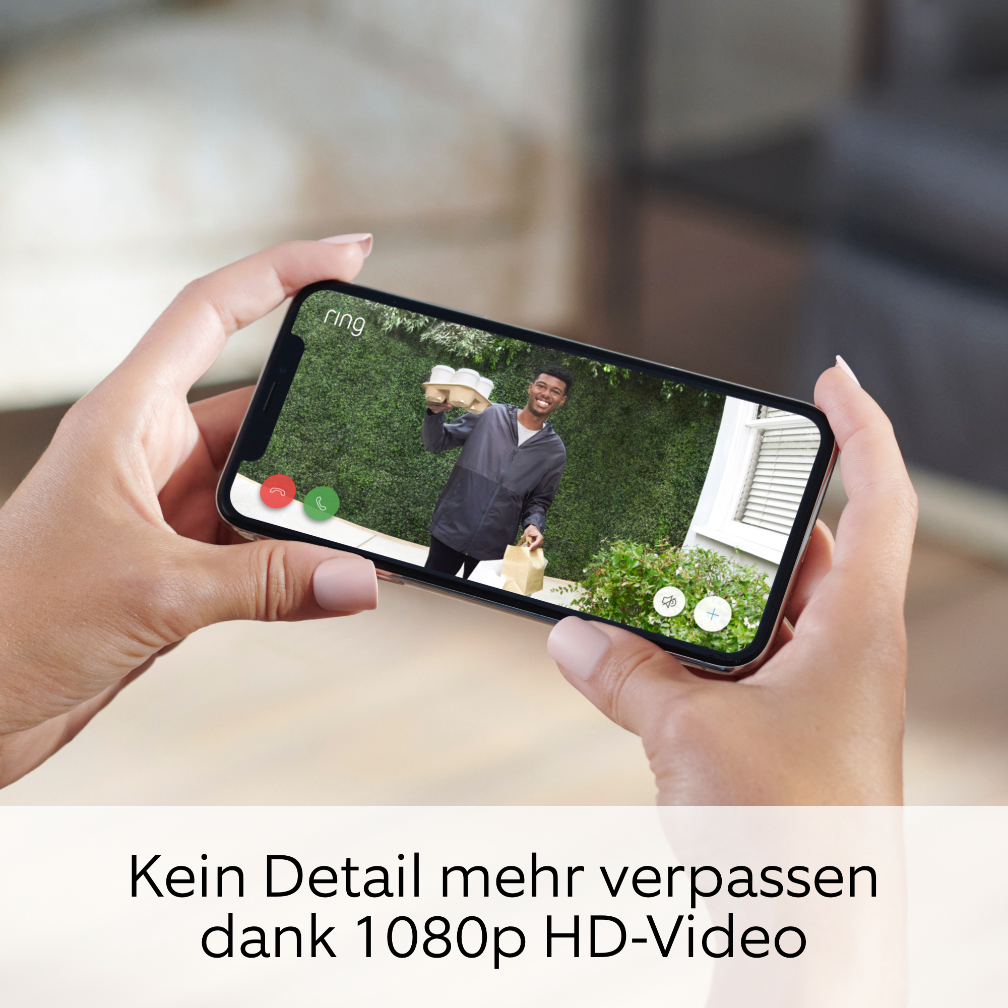 Hände halten ein Telefon, das ein Video eines Zustellers an einer Haustür zeigt.