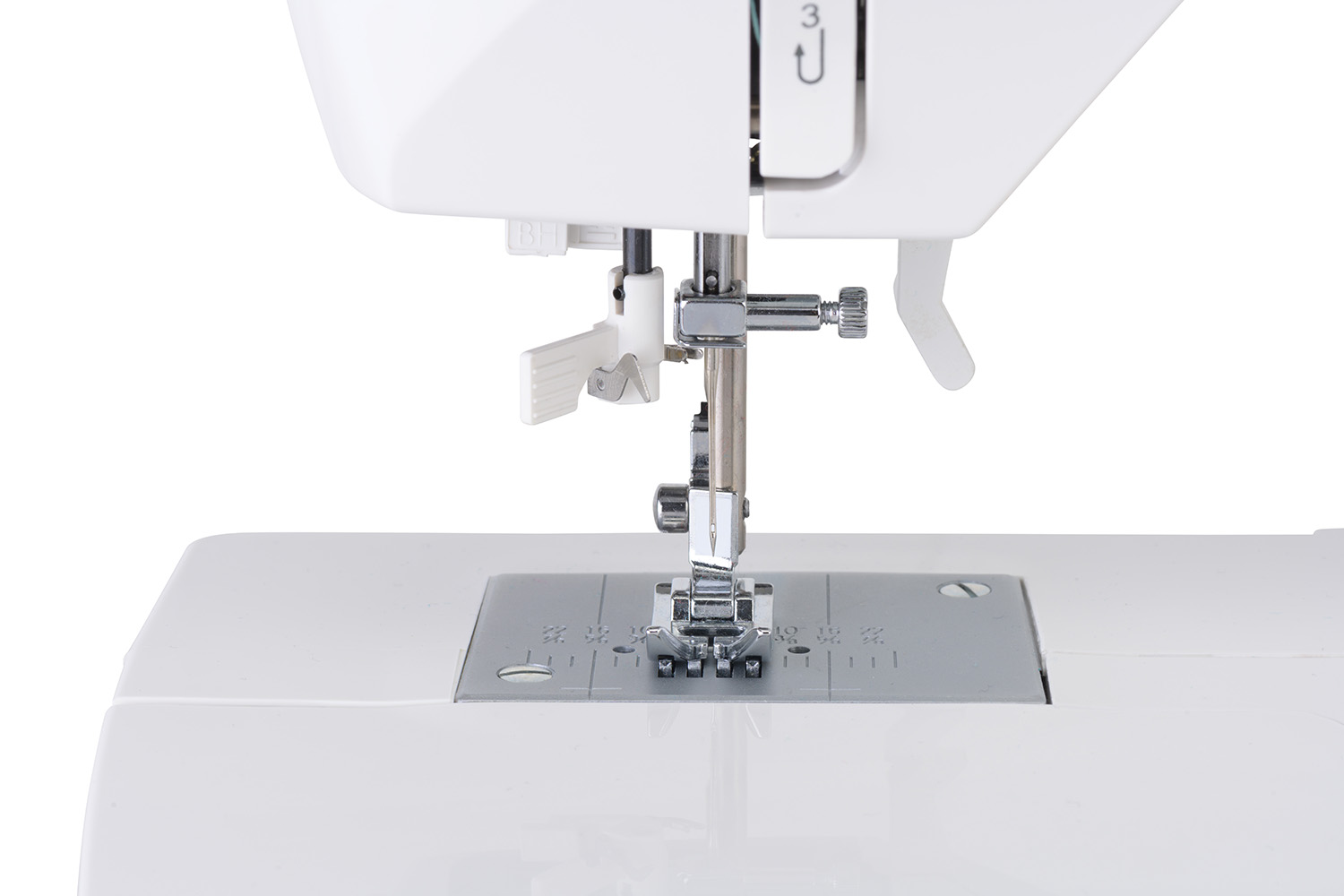 Close-up van een witte naaimachine: naald, naaivoet en steekplaat zichtbaar.