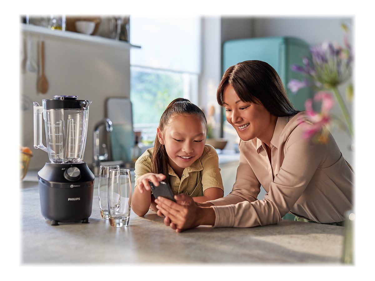 Frau und Mädchen schauen auf ein Telefon neben einem schwarzen Philips-Mixer.
