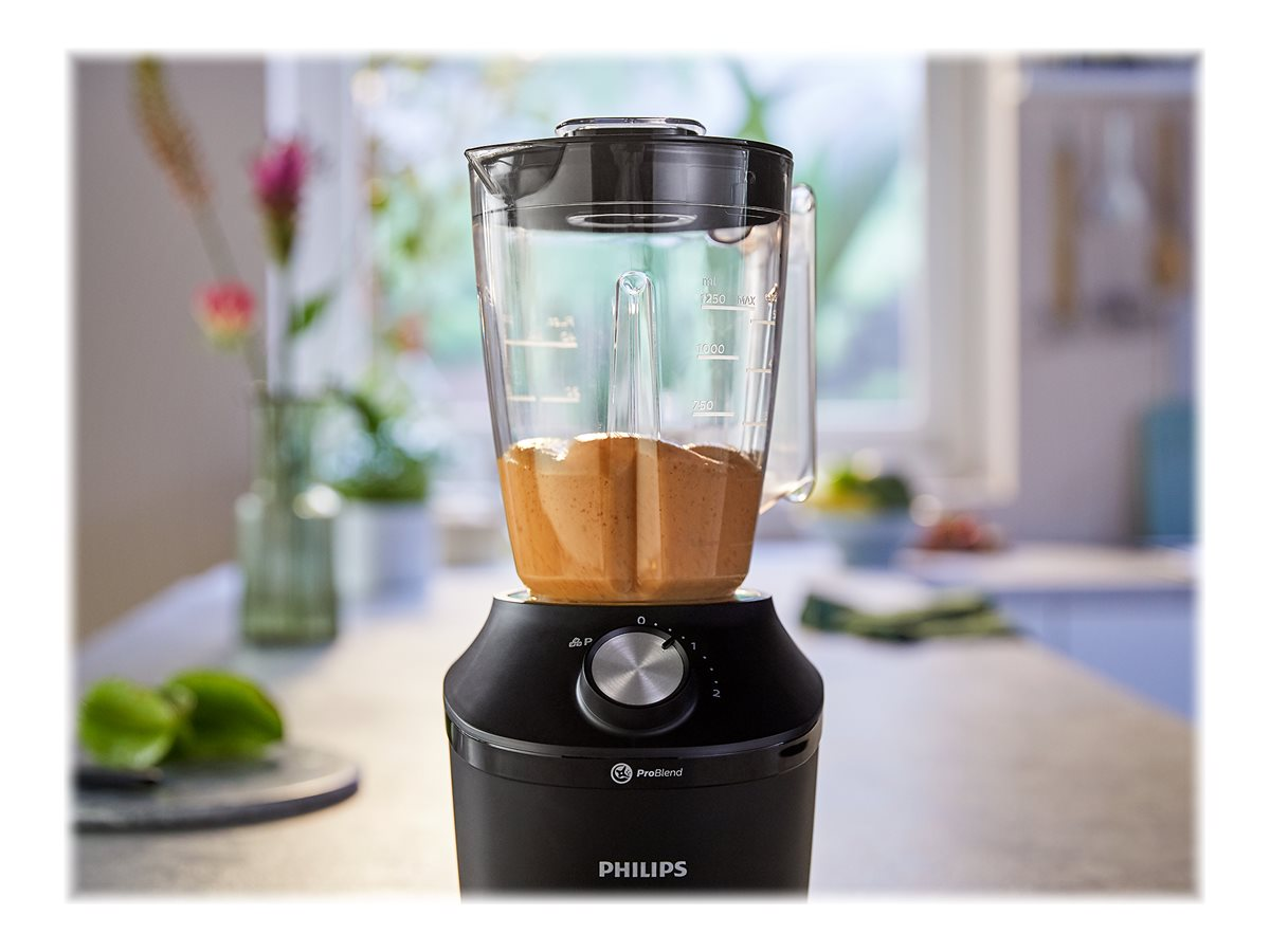 Ein schwarzer Mixer mit einem durchsichtigen Behälter voller braunem Smoothie. Der Mixer steht auf einer Theke.