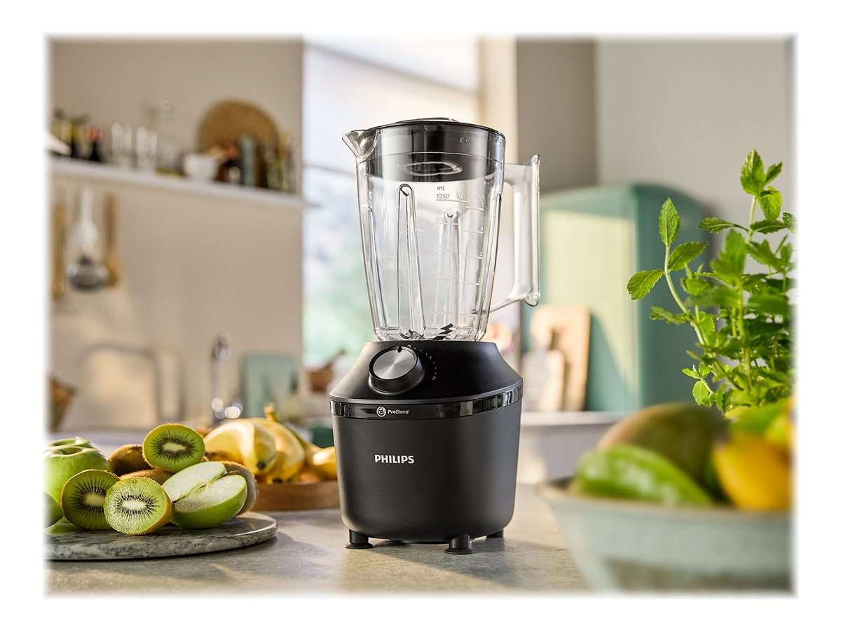 Schwarzer Philips-Mixer mit Glasbehälter auf der Küchentheke. Obst in der Nähe.