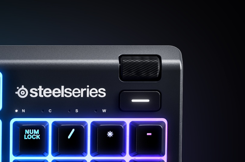 Close-up van een zwart toetsenbord met het SteelSeries-logo en een rolwiel. Toetsen met licht.
