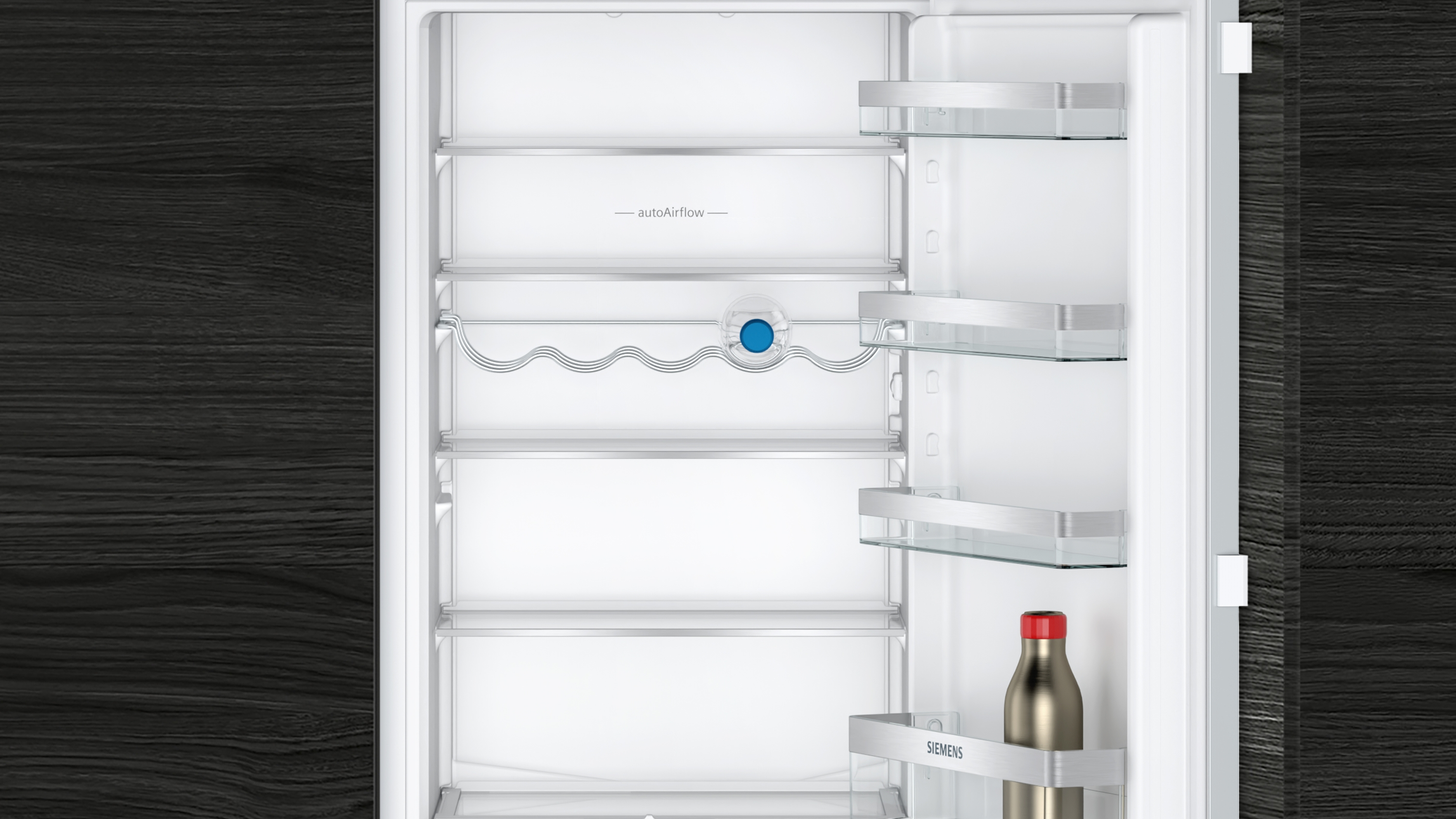 Offener Kühlschrank mit Regalen, Flasche auf dem untersten Regal. Weißer Innenraum, dunkler Holzuntergrund.