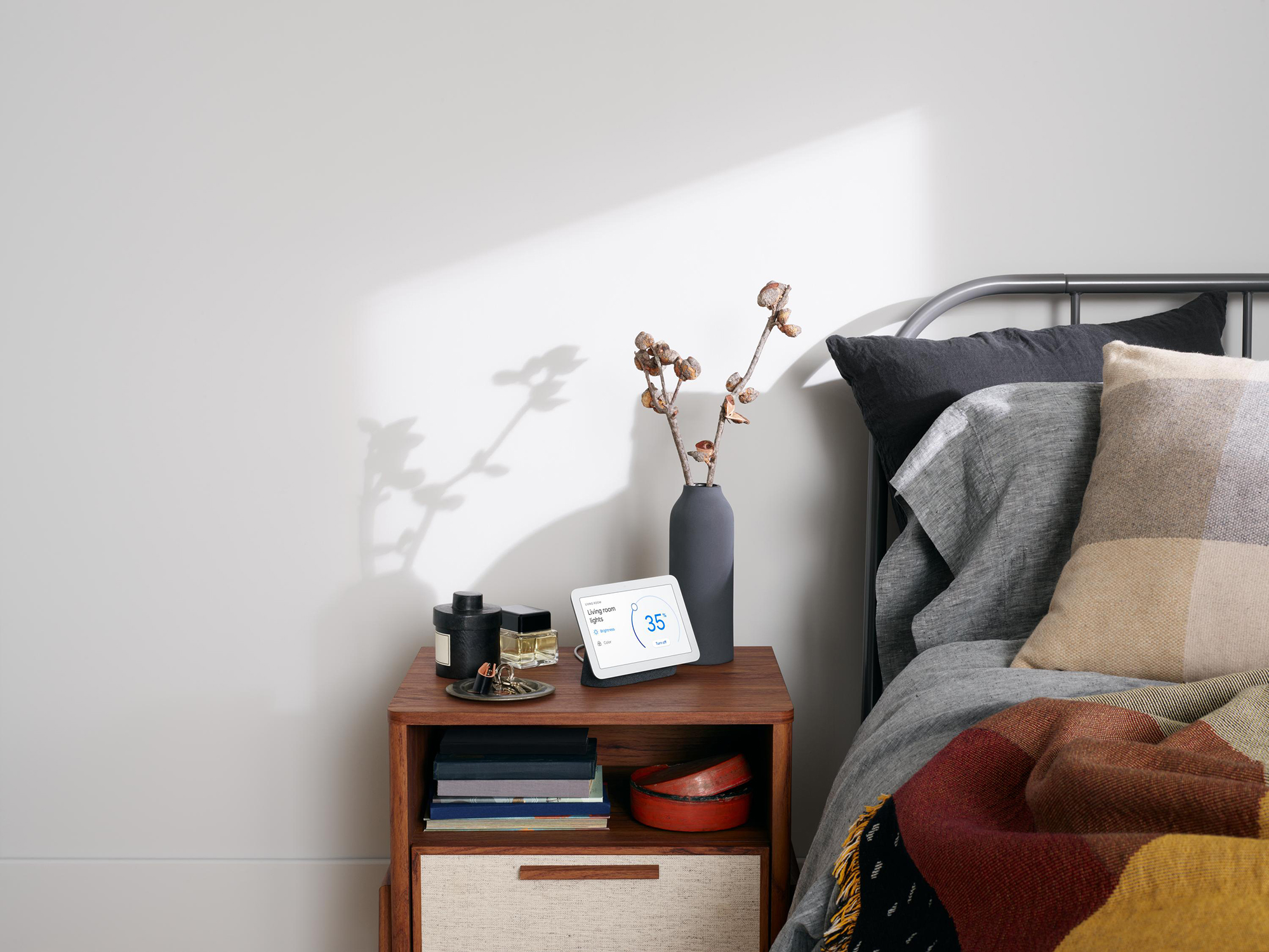 Slaapkamer met nachtkastje, Google Nest, vaas en bed.