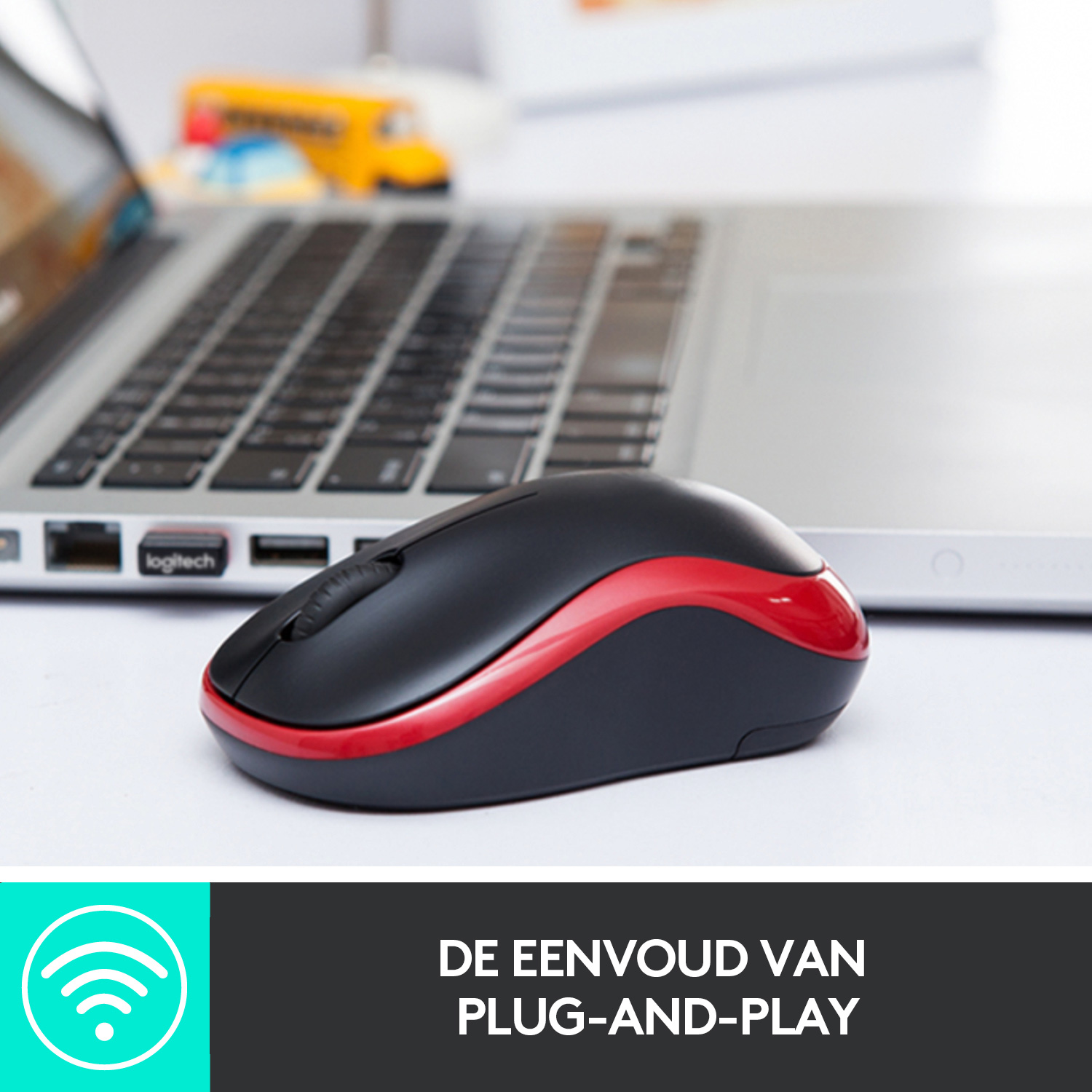 A black and red wireless mouse next to a laptop on a white surface.