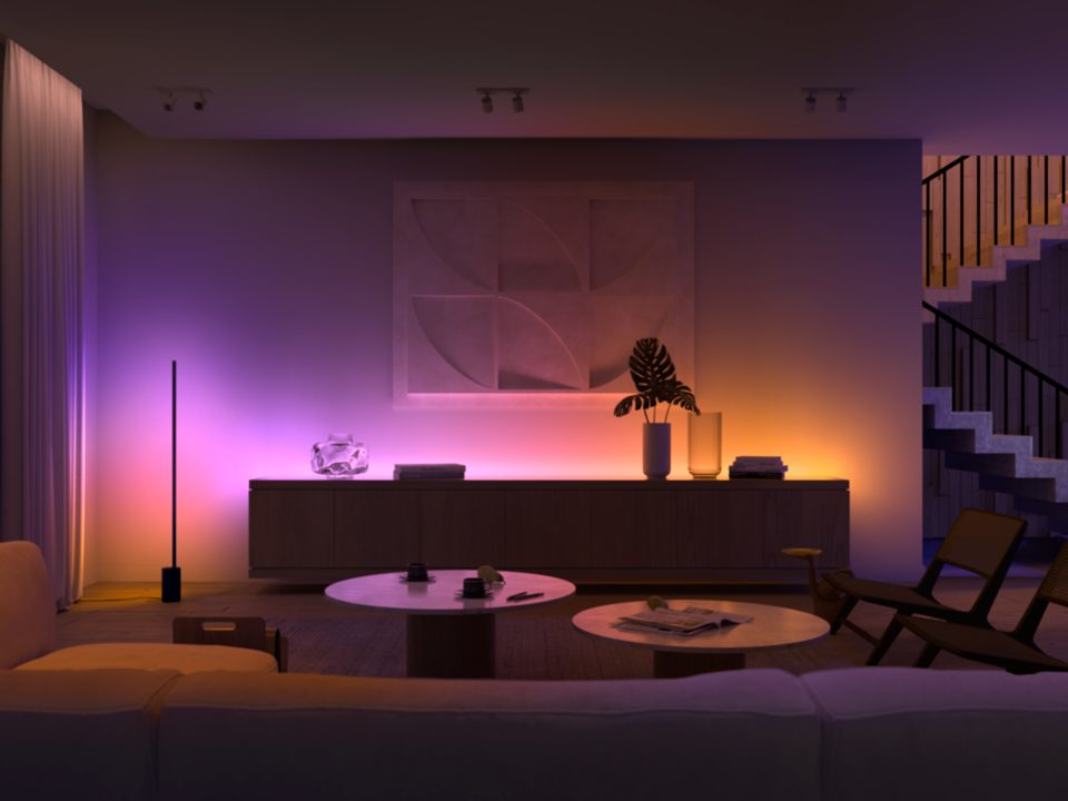Living room with a white sofa and a lamp. Wall art above a wooden cabinet. Warm lighting.