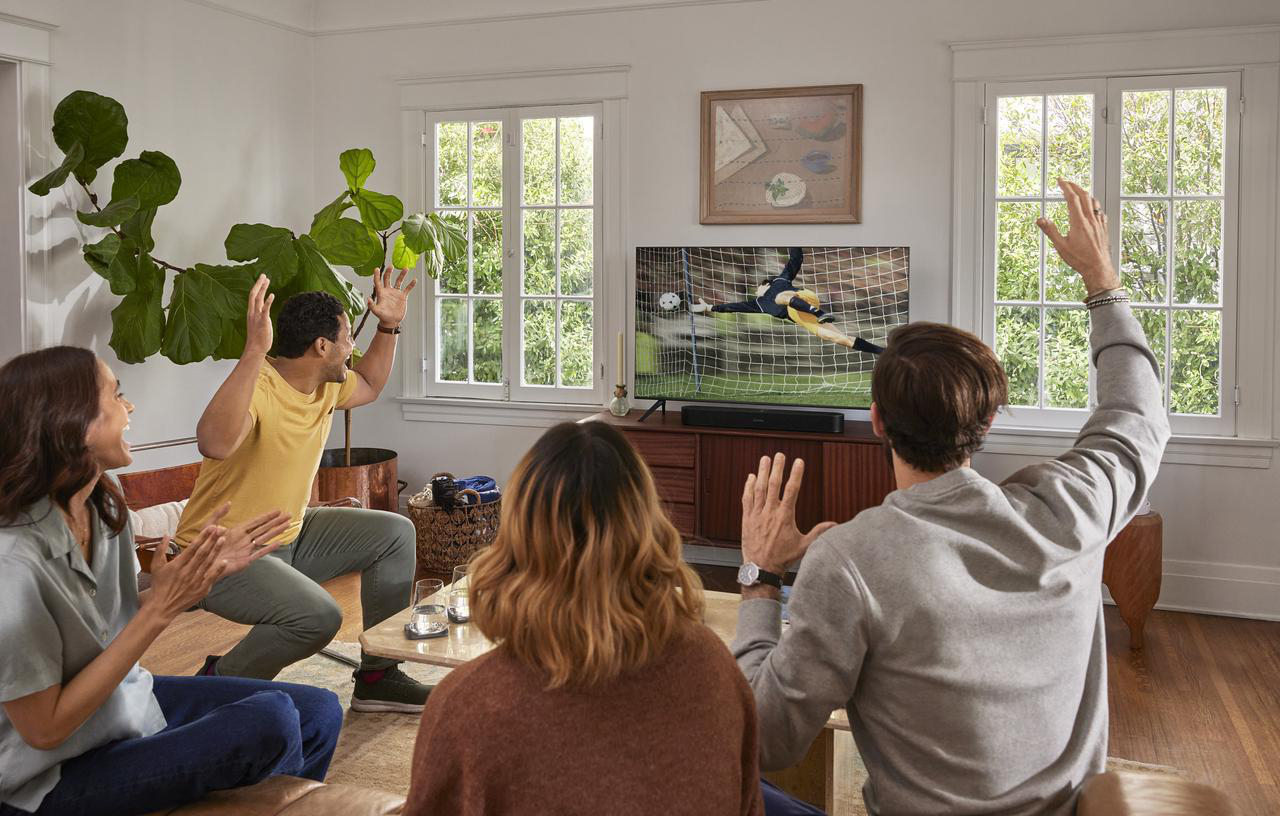 Leute schauen ein Fußballspiel im Fernsehen, aufgeregt und jubeln.