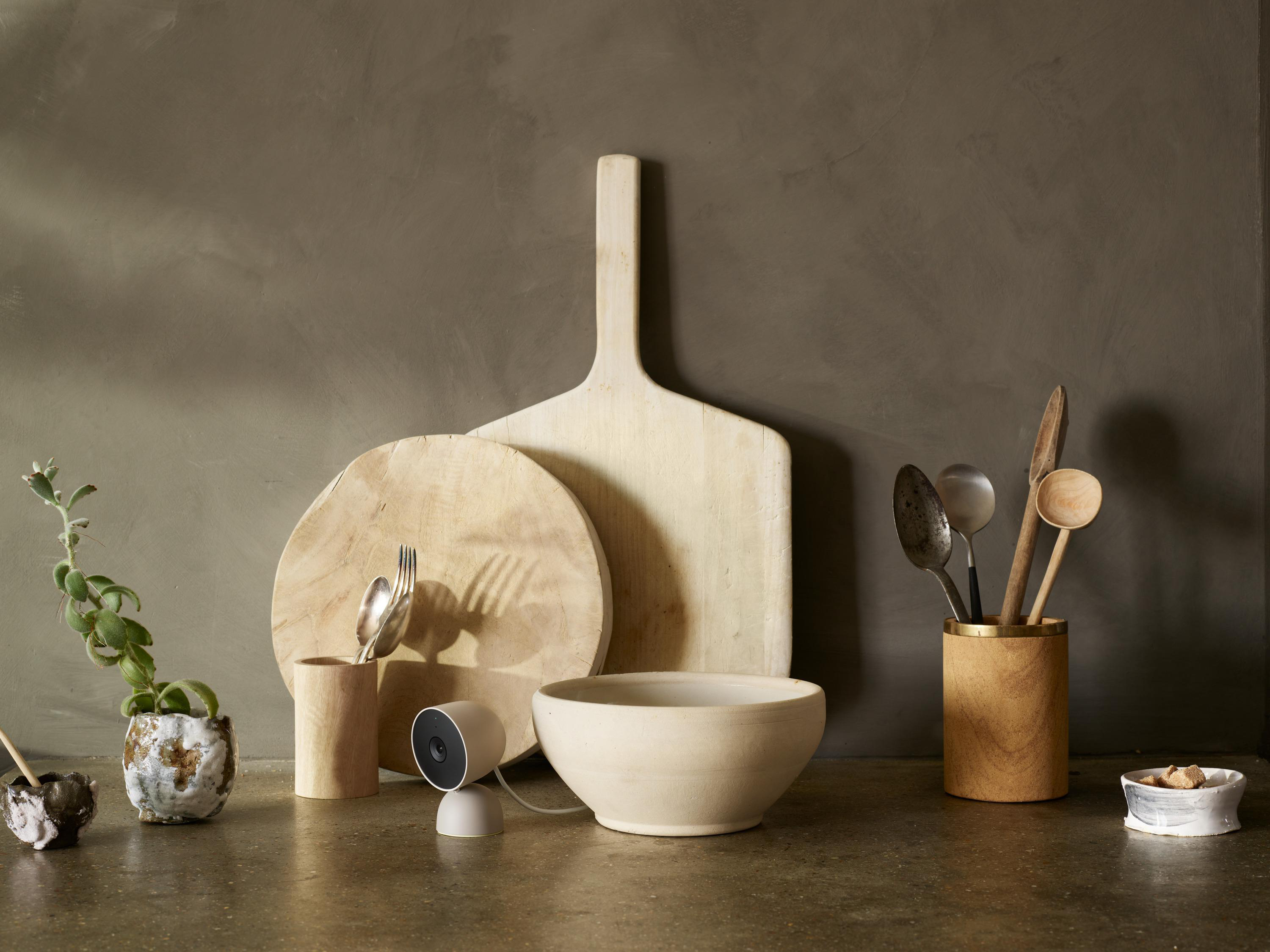 Küchentheke mit Holzbrettern, Schalen, Utensilien und einer weißen Sicherheitskamera.