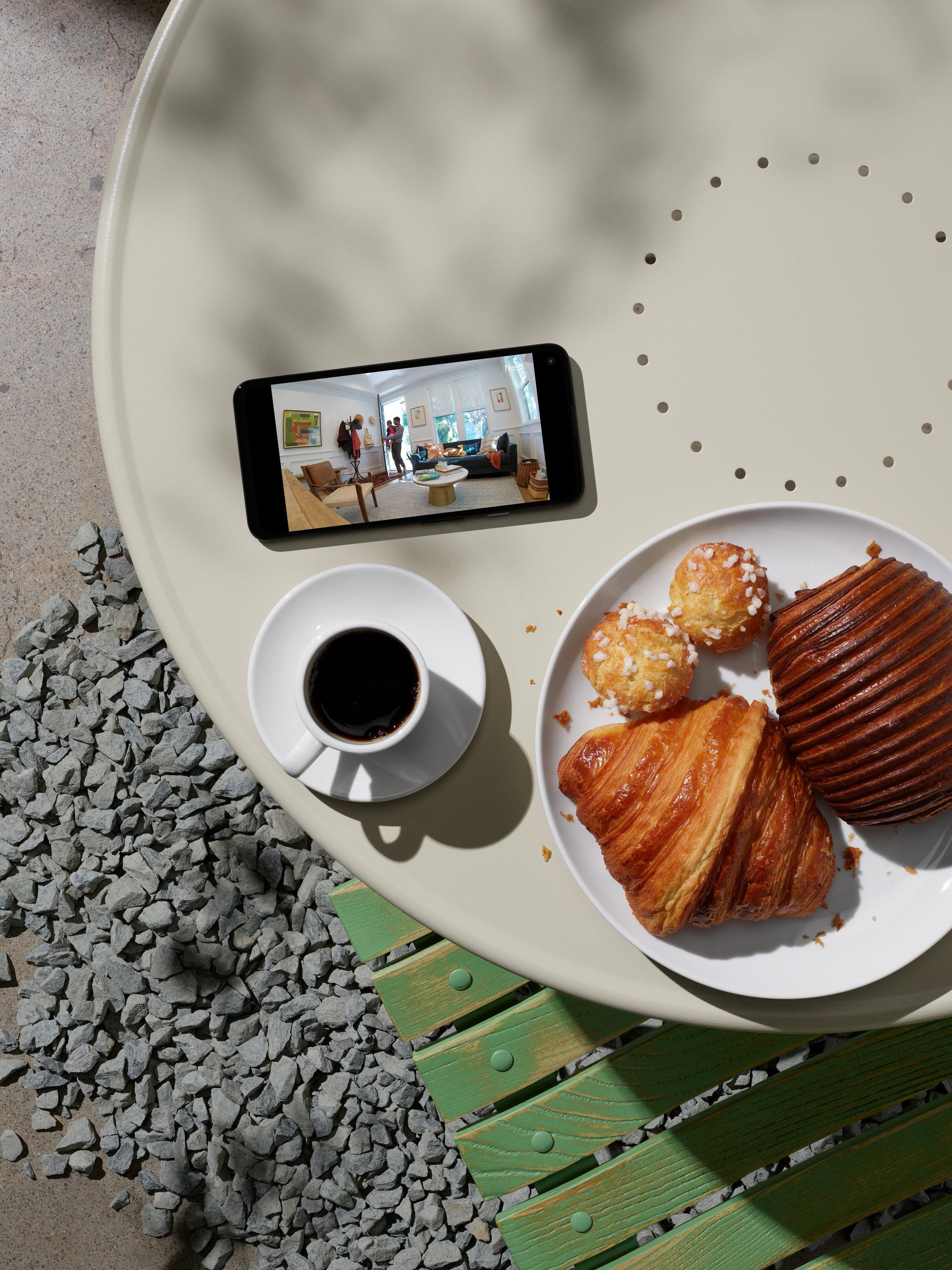 Ein Telefon mit Essen und Kaffee auf einem Tisch.