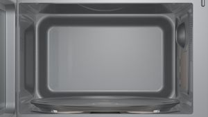 Innere einer Mikrowelle mit Glasplatte. Grauer Innenraum.