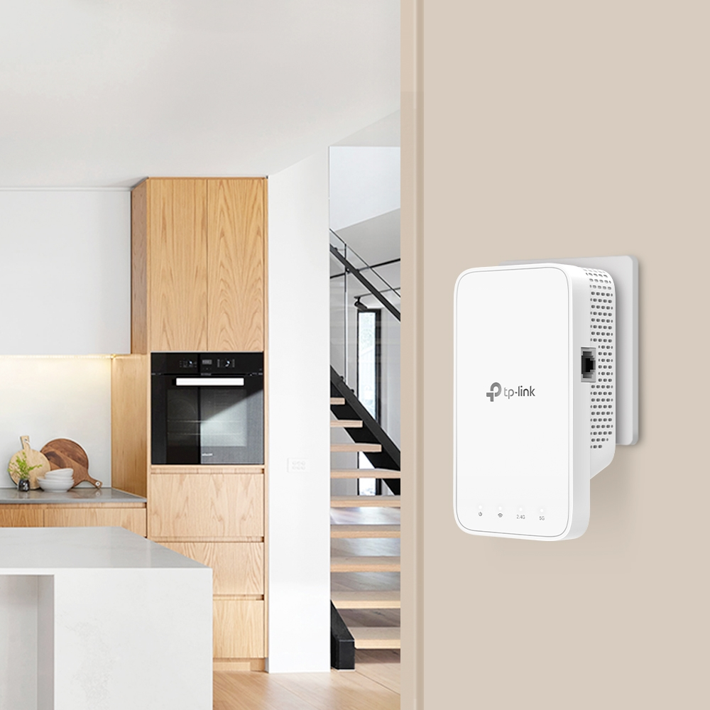 Weißer TP-Link-Extender an einer Wand vor einer Küche montiert.