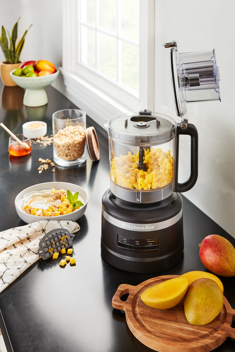Küchenmaschine mit gehackten Mangos, andere Zutaten drumherum.