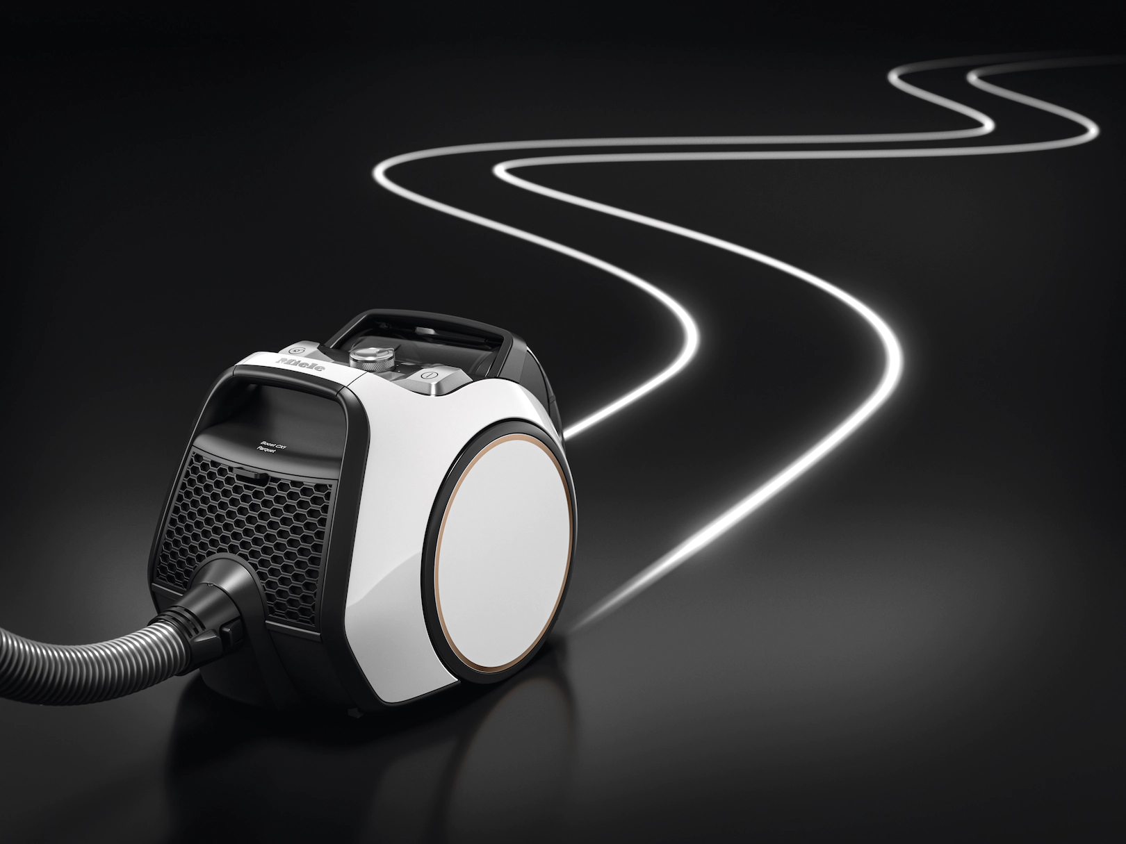 Un aspirateur sur une surface noire, avec une ligne blanche suggérant un chemin. L'aspirateur est blanc et noir.