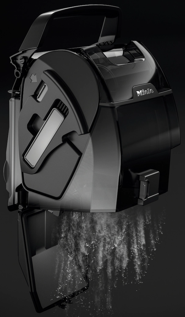 Un aspirateur noir avec un conteneur à poussière transparent, des particules de poussière tombent.