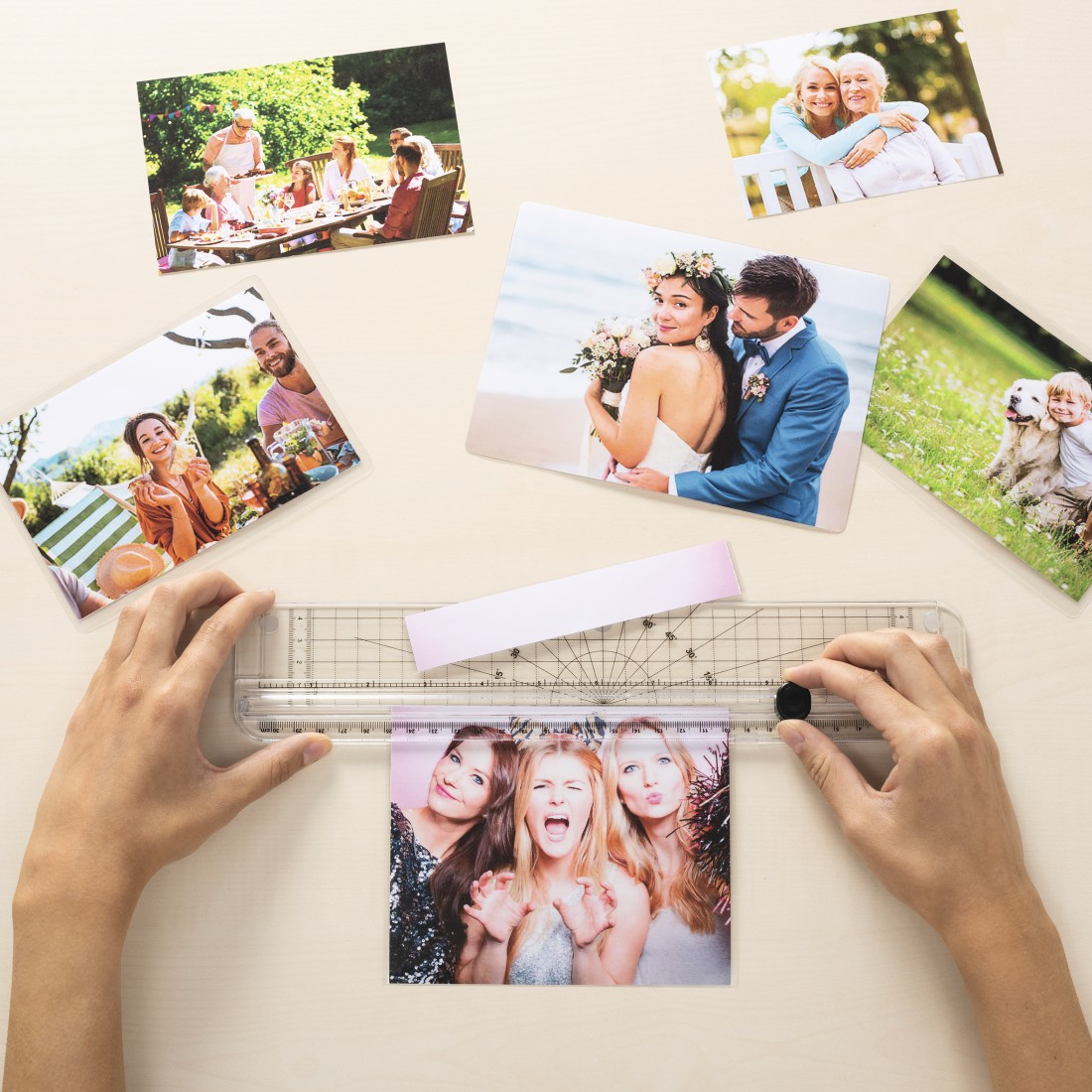 Fotos auf einem Tisch werden mit einem Lineal gemessen. Die Personen auf den Fotos lächeln.