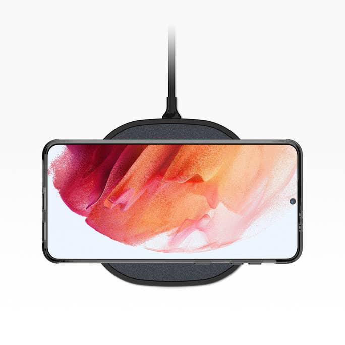 Ein Telefon liegt auf einem kabellosen Ladegerät. Das Telefon zeigt ein farbenfrohes abstraktes Bild.