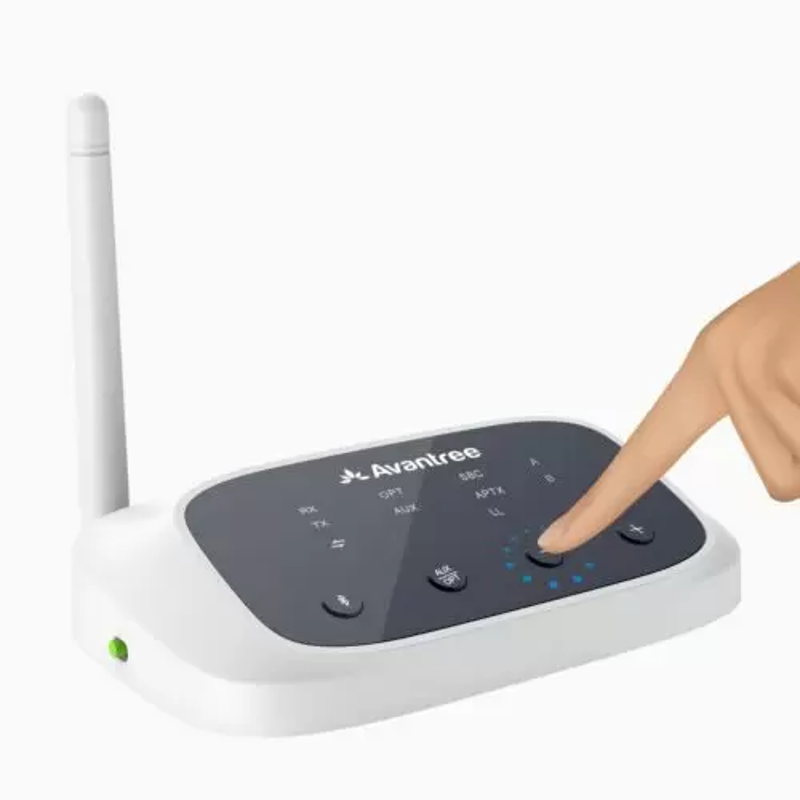 Appareil audio Avantree blanc, avec un doigt appuyant sur un bouton. Fond noir.