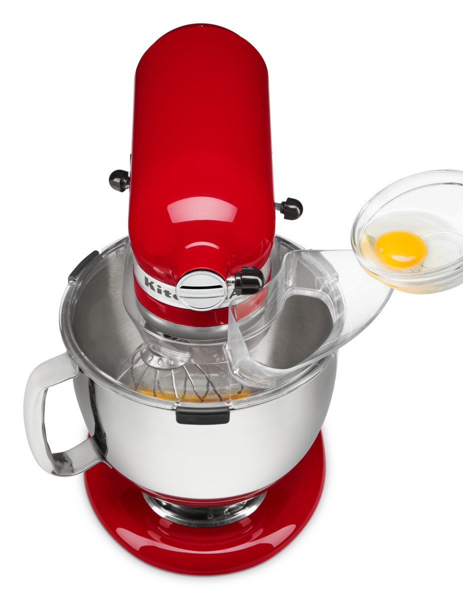 Roter KitchenAid-Mixer mit Schüssel und Ei, das hinzugefügt wird.