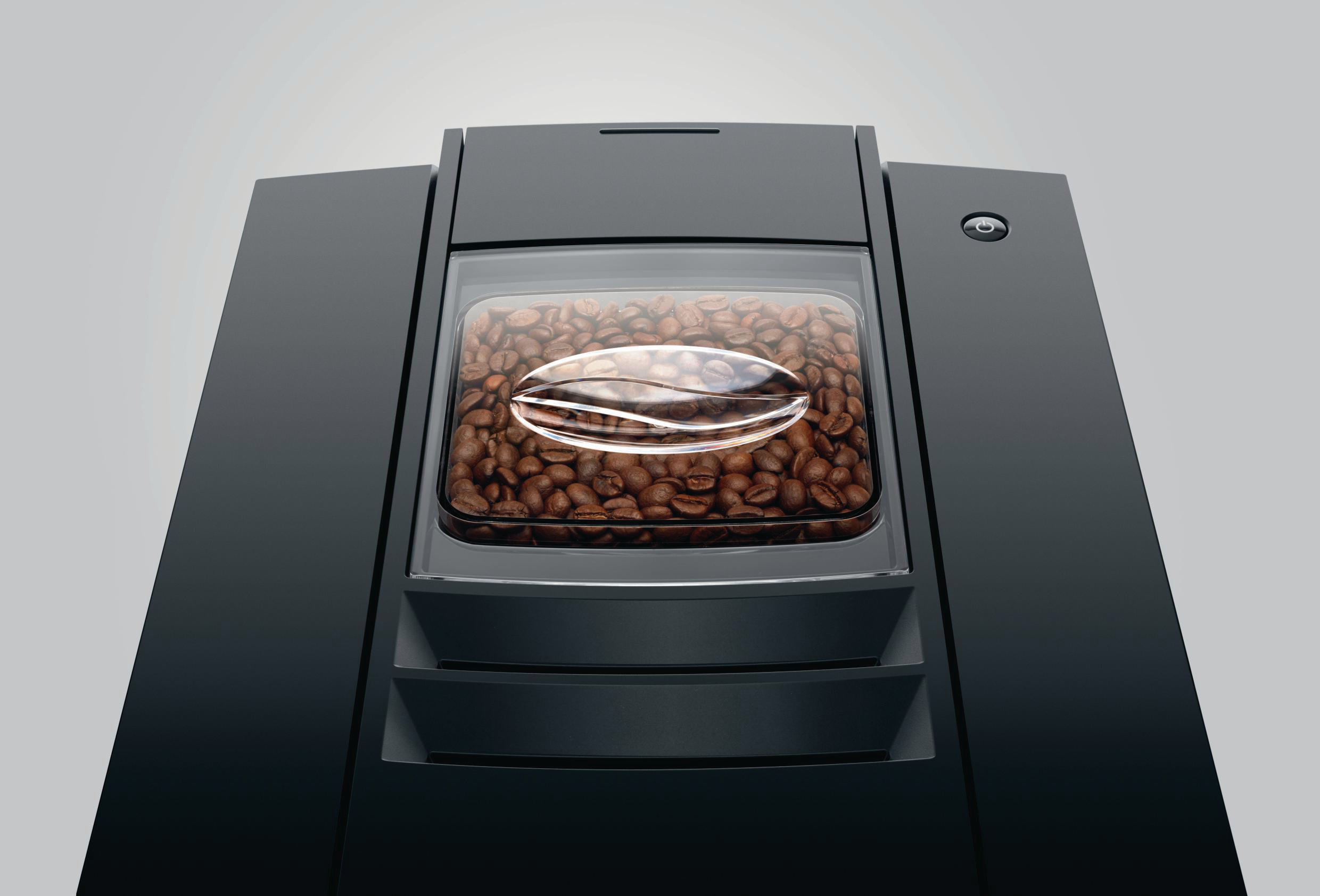 Kaffeemaschine mit Kaffeebohnen in einem transparenten Behälter oben.