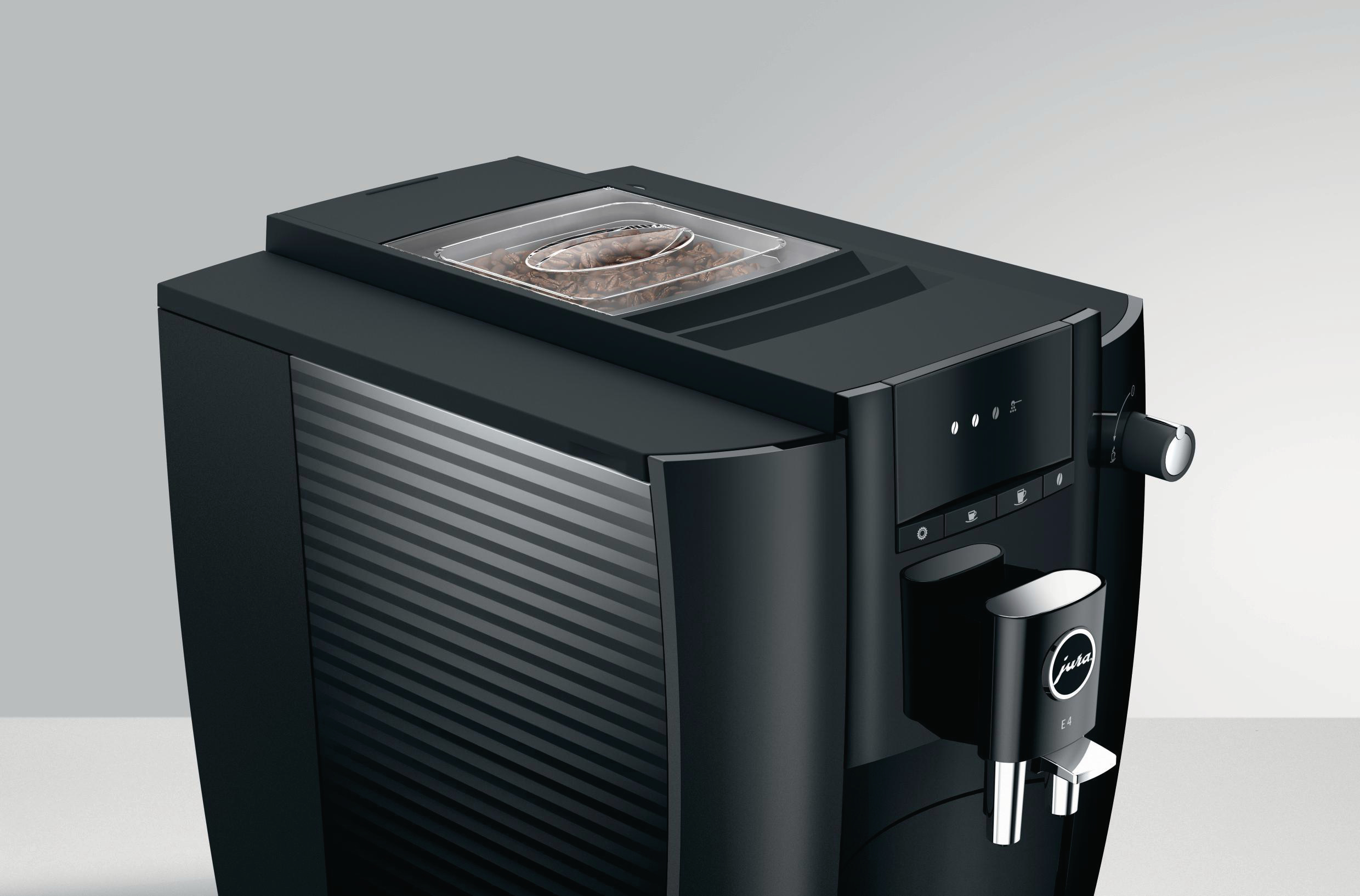 Schwarze Kaffeemaschine mit Bohnen im Behälter. Es hat Knöpfe und einen Ausguss.