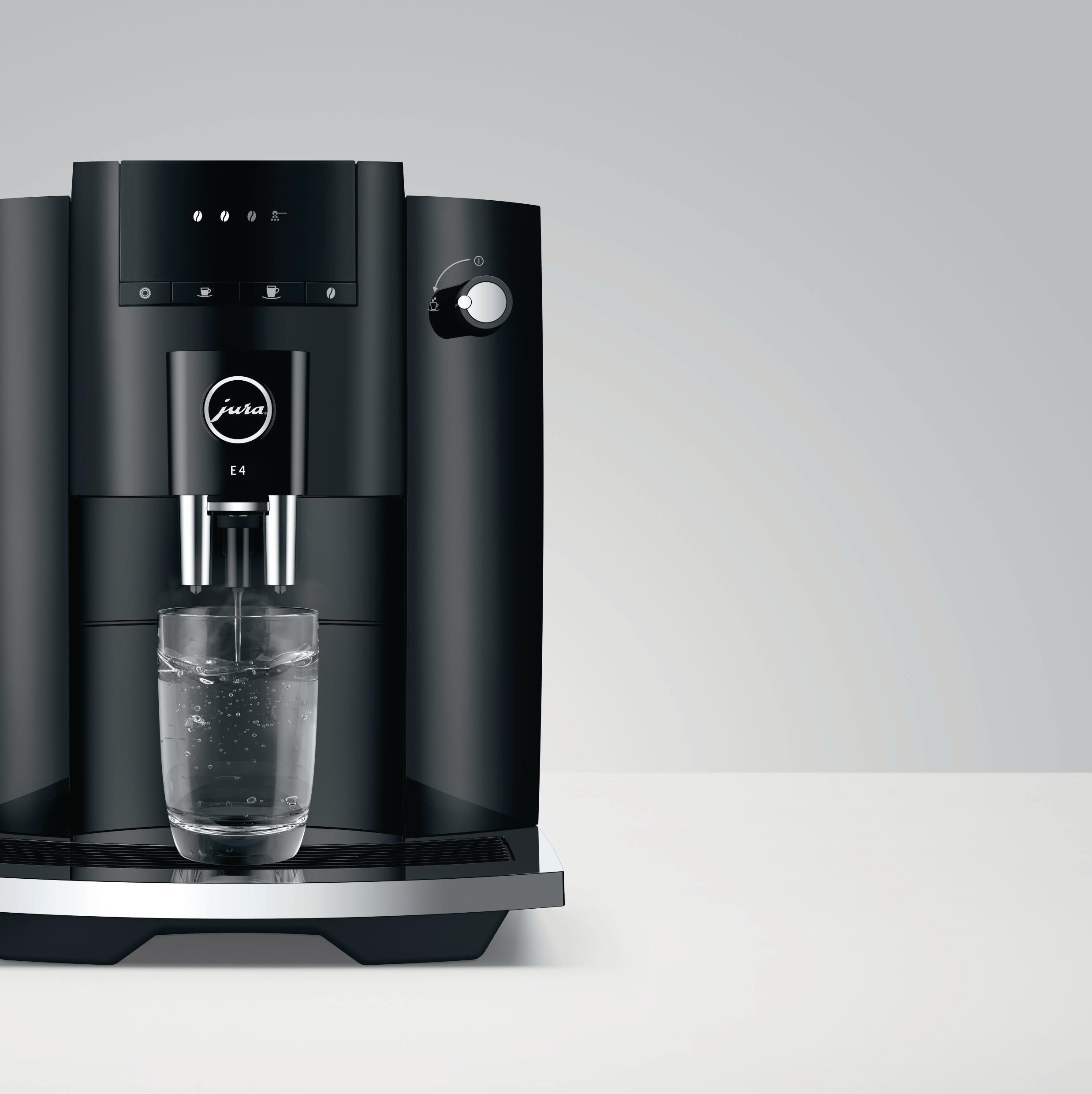Schwarze Jura E4 Kaffeemaschine, aus der ein Glas Wasser abgefüllt wird.