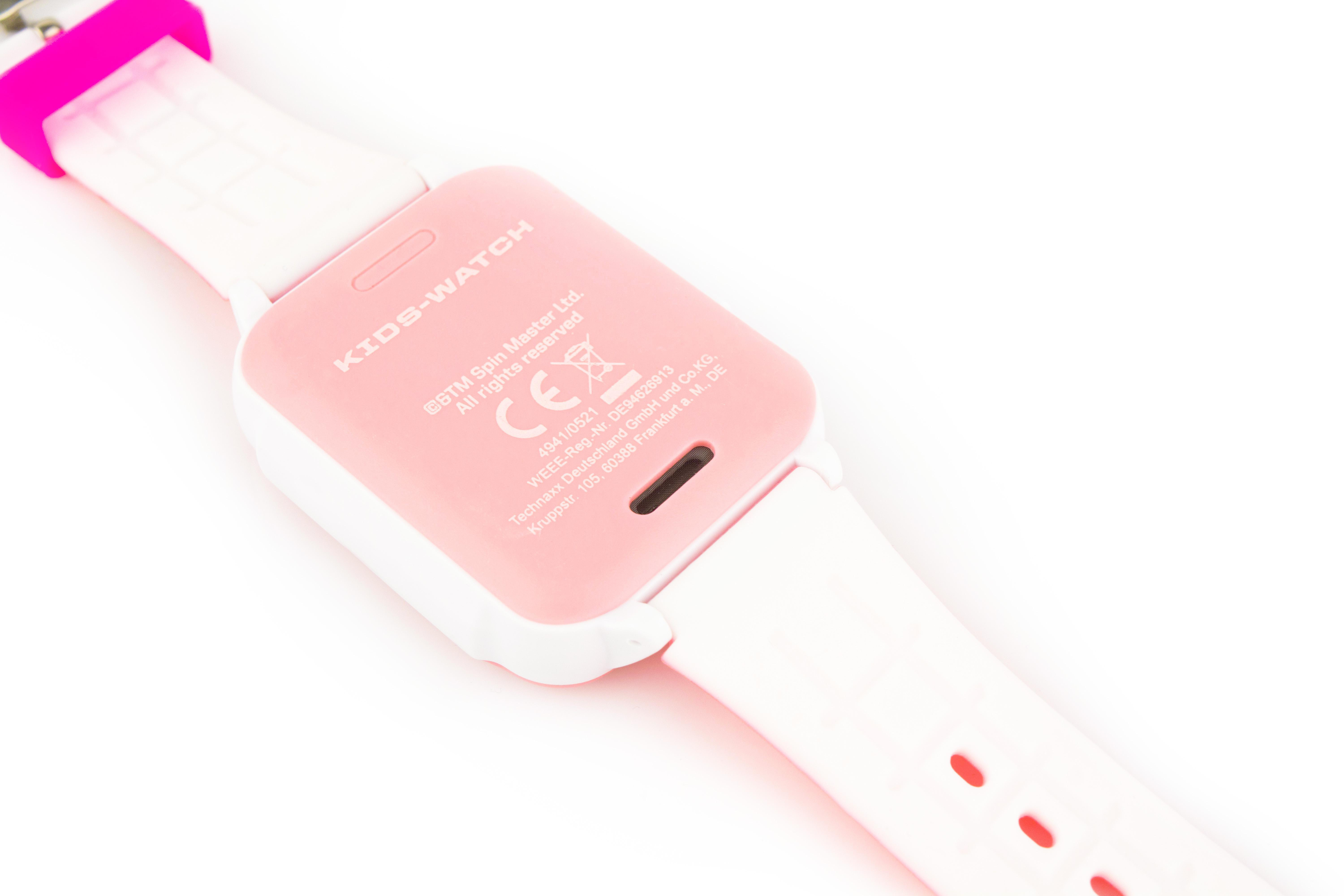Die Rückseite einer rosa und weißen Kinder-Smartwatch mit Text und Ladeanschluss.