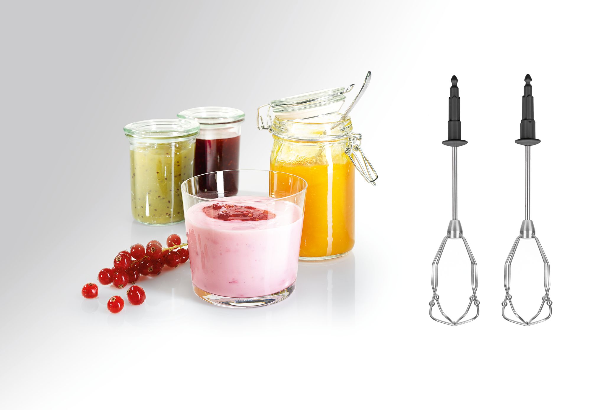 Dzsemes üvegek és egy pohár joghurt gyümölccsel, habverőkkel.
