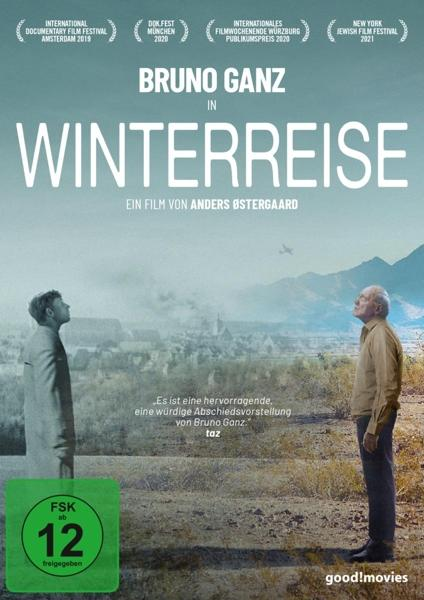 Filmplakat: Bruno Ganz in Winterreise. Zwei Männer stehen, schneebedeckte Landschaft, Berge und Text.