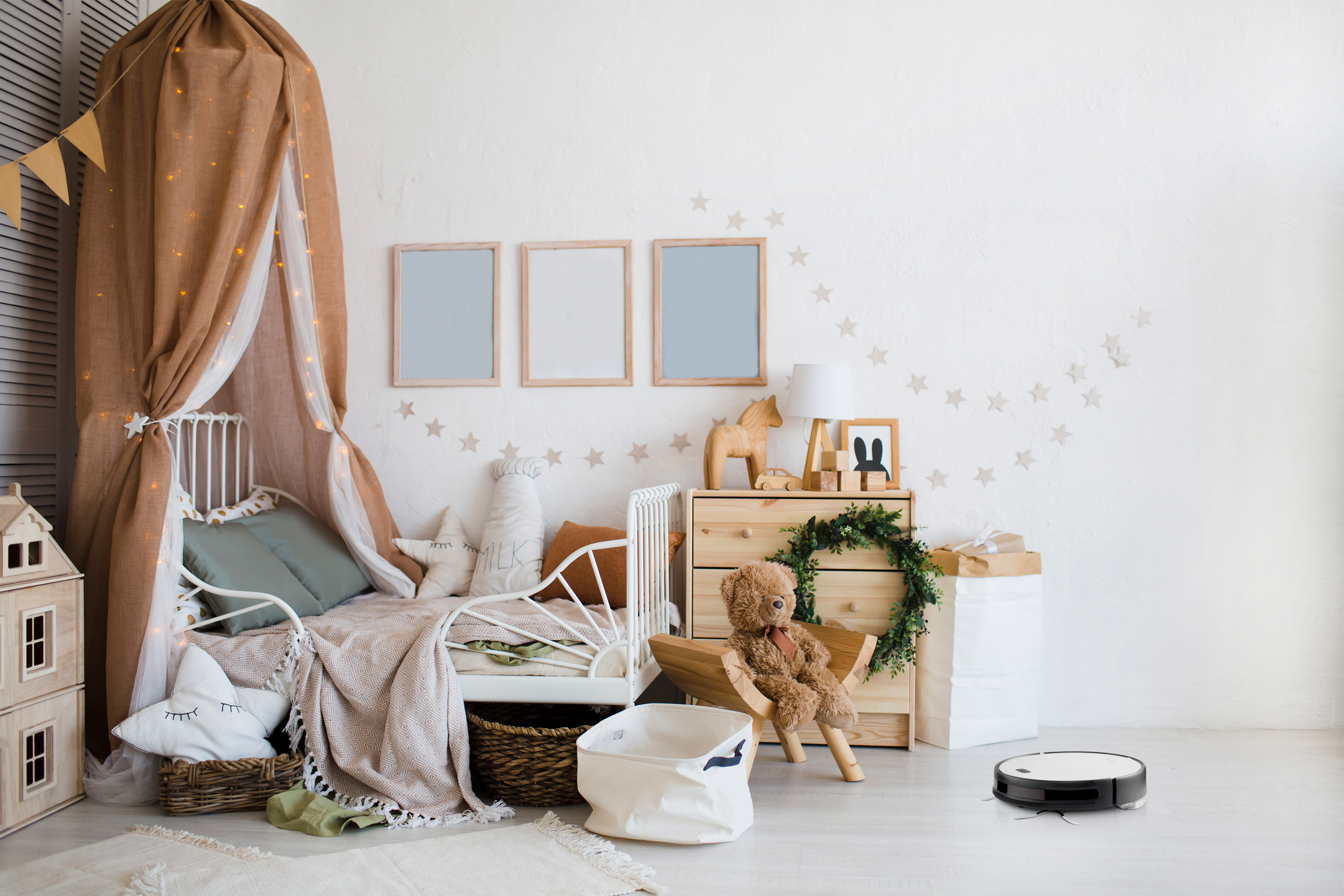 Ein Kinderzimmer mit einem Bett, einer Kommode und einem Roboter-Staubsauger auf dem Boden.