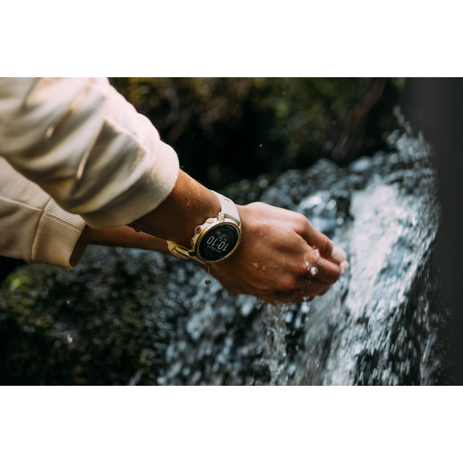 Las manos de una persona, con un reloj, se sostienen bajo un chorro de agua. El reloj muestra la hora.