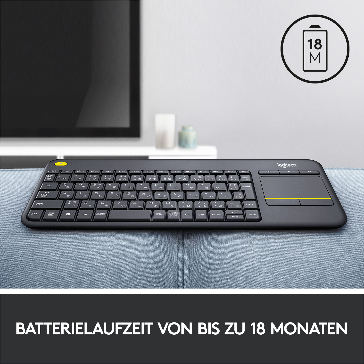 Schwarze Tastatur mit japanischem Layout. Gelbes Trackpad und Text 'Batterielaufzeit von bis zu 18 Monaten'.
