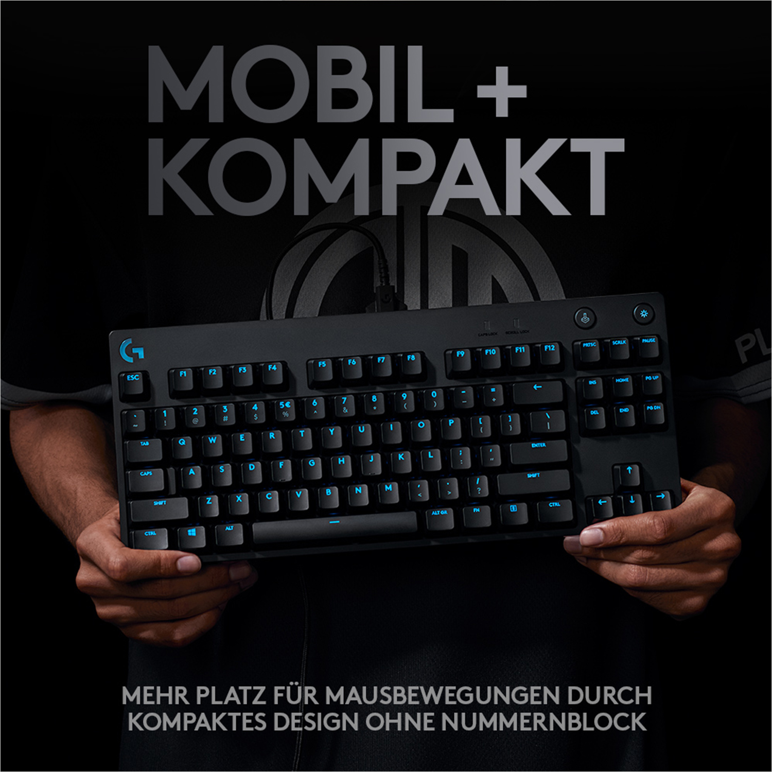 Schwarze Tastatur mit blau beleuchteten Tasten, gehalten von Händen vor dunklem Hintergrund.