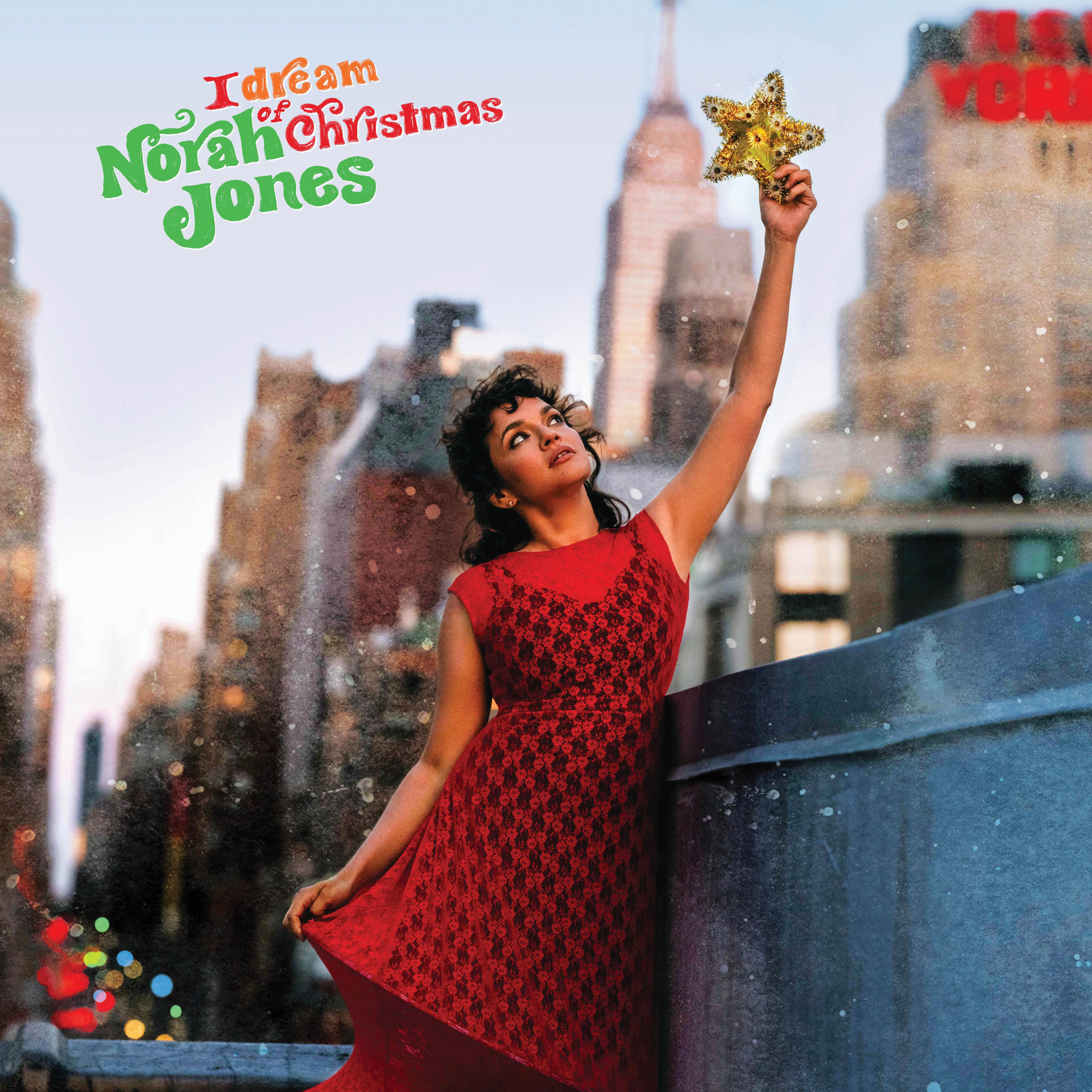 Albumhoes van Norah Jones. Ze draagt een rode jurk en houdt een gouden ster vast, skyline van NYC op de achtergrond.