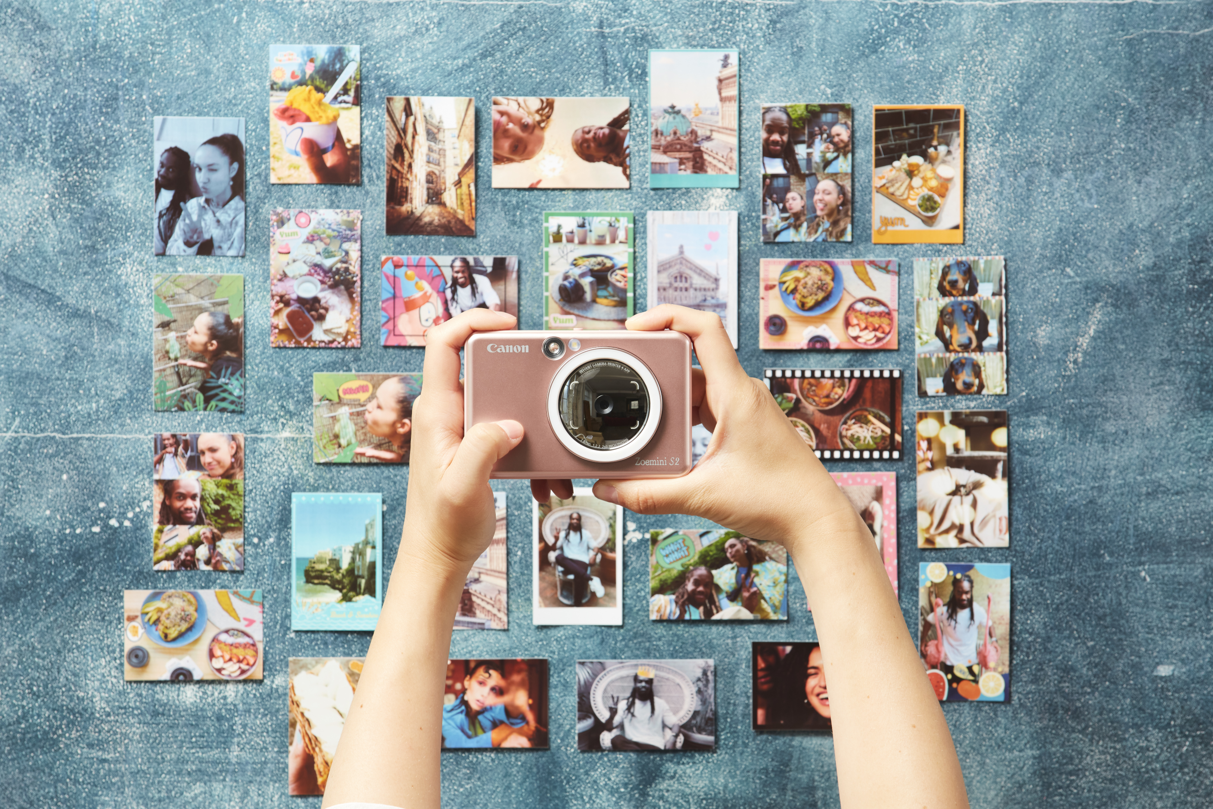 Person hält eine rosa Kamera, umgeben von Fotos. Bilder von Menschen, Essen und Orten sind sichtbar.
