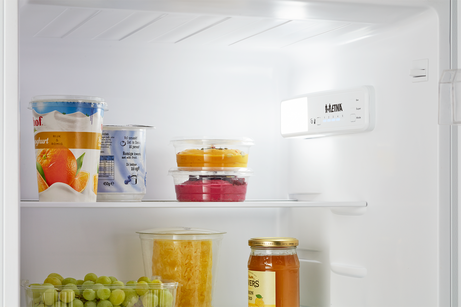 Inside a refrigerator: food containers, yogurt, and a temperature control panel.