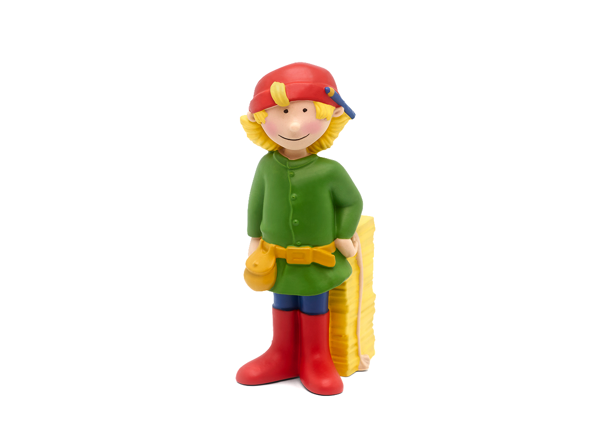 Eine kleine Kinderfigur mit rotem Hut und grünen Kleidern, die sich an einen Heuballen lehnt.