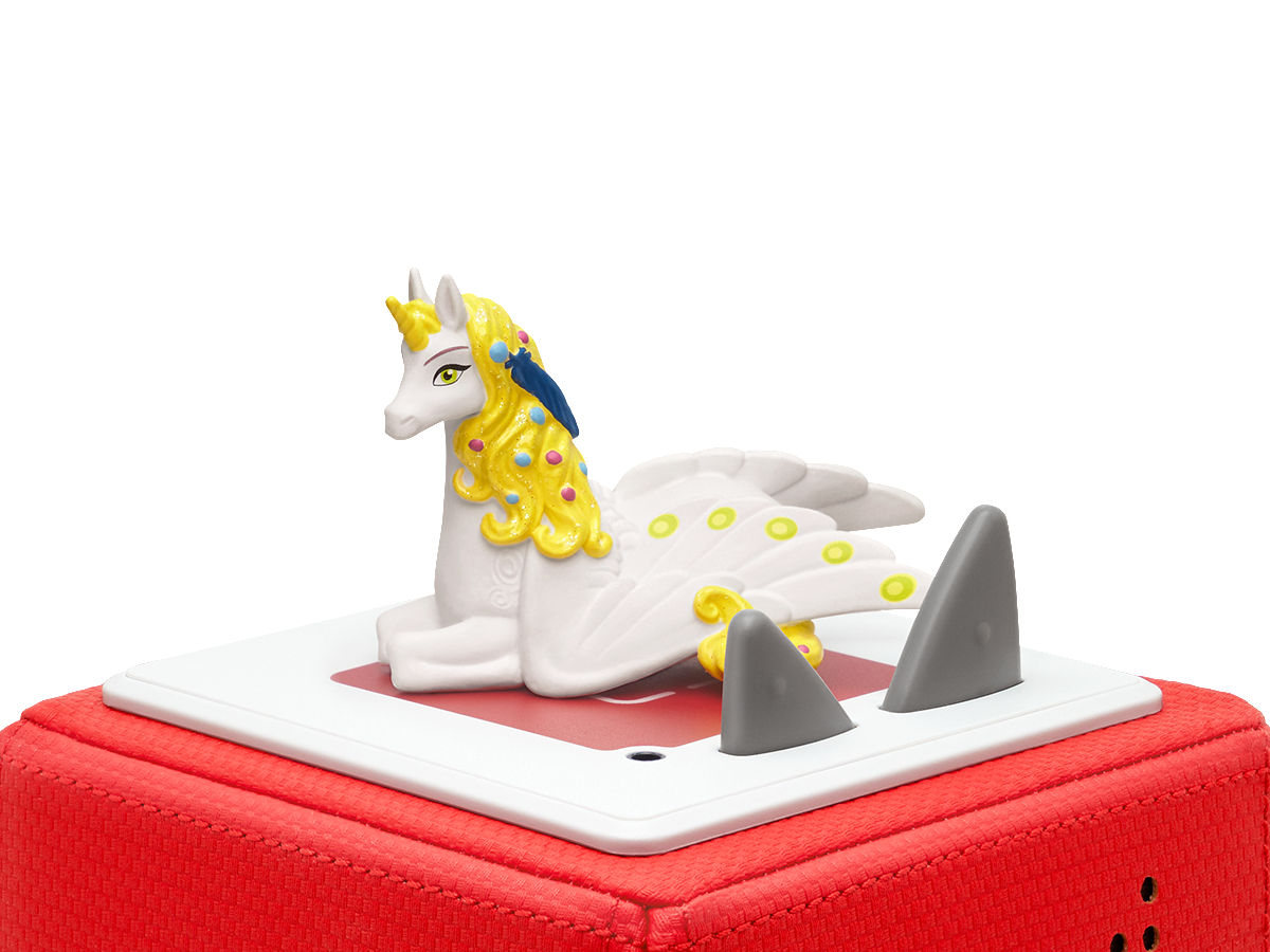 Ein Einhornspielzeug auf roter Basis mit Haiflossen. Weißer Hintergrund.