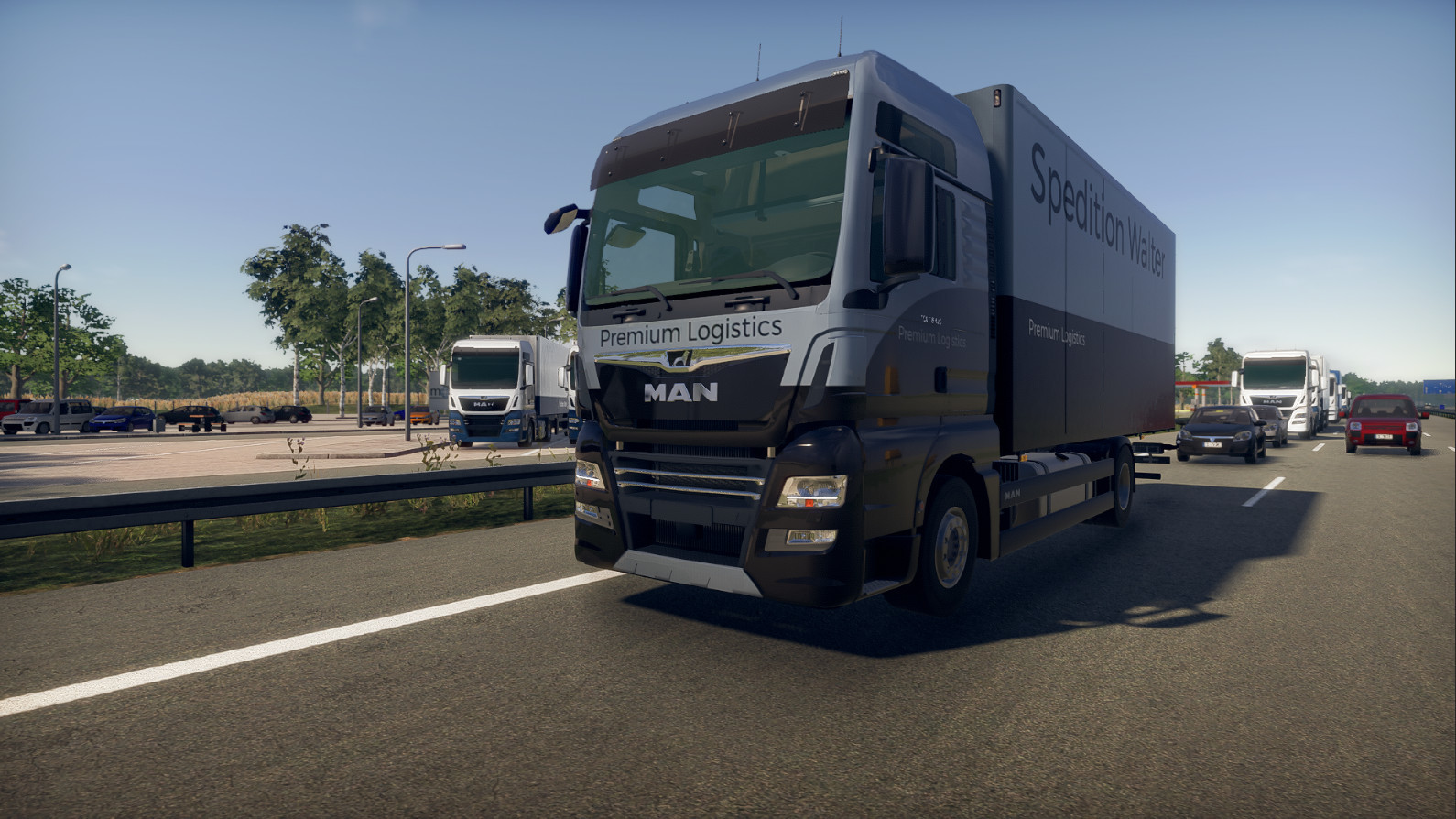 Un camion di grandi dimensioni con il testo 'Premium Logistics' sul lato, che viaggia su un'autostrada. Altri veicoli e alberi sono in vista.