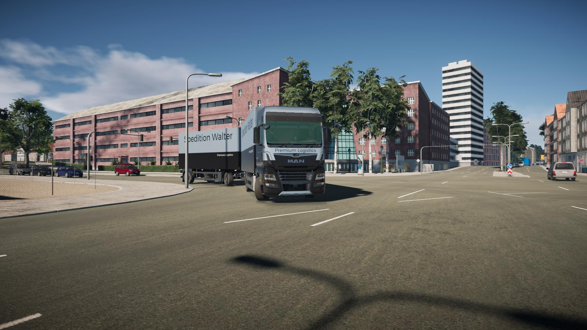 Camion su una strada cittadina, con edifici e cielo blu sullo sfondo.