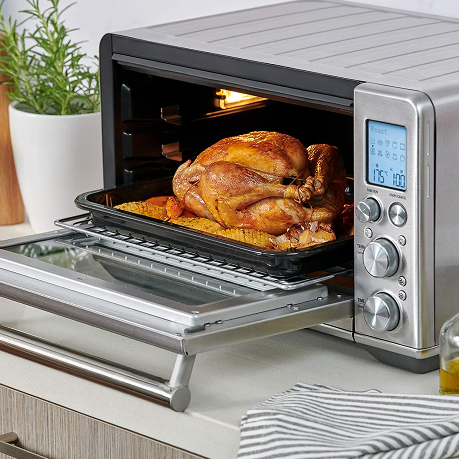 Un forno con un pollo e verdure cotti all'interno. Il forno è impostato sulla modalità arrosto. Sfondo bianco.