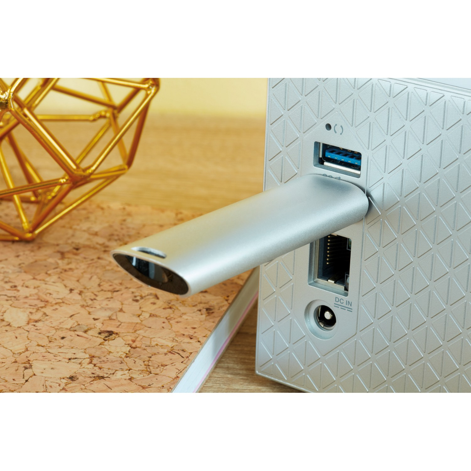 Memoria USB plateada conectada a un dispositivo plateado con puertos.