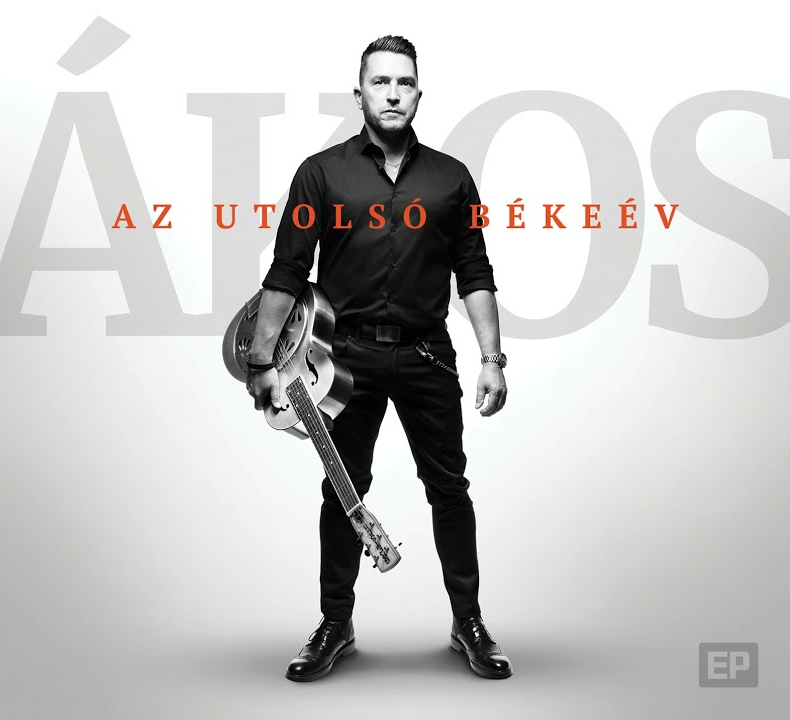 Ákos album borító: férfi gitárral, fekete ingben, fekete nadrágban áll.