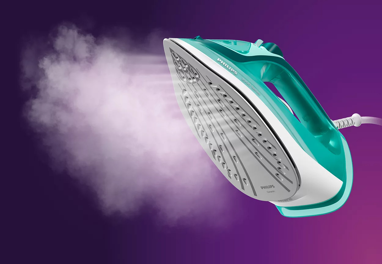 Un fer à repasser turquoise avec de la vapeur sur fond violet.