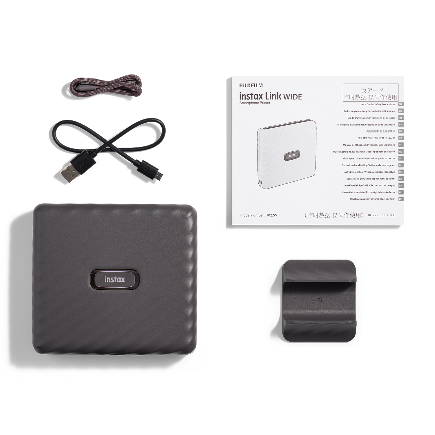 Stampante Instax Link WIDE e accessori, tra cui un cavo USB e il manuale.
