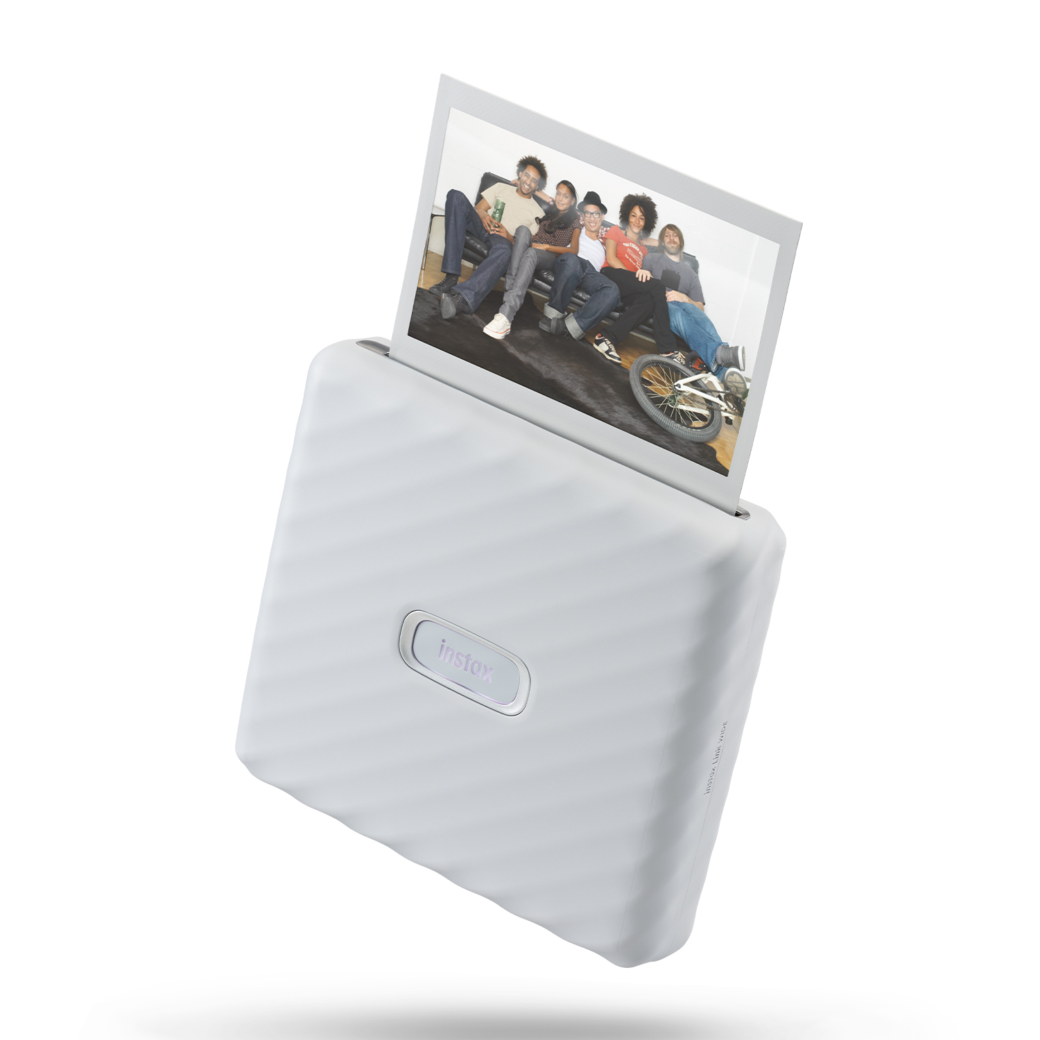 Stampante Instax bianca che espelle una foto con un gruppo di persone. Superficie bianca.