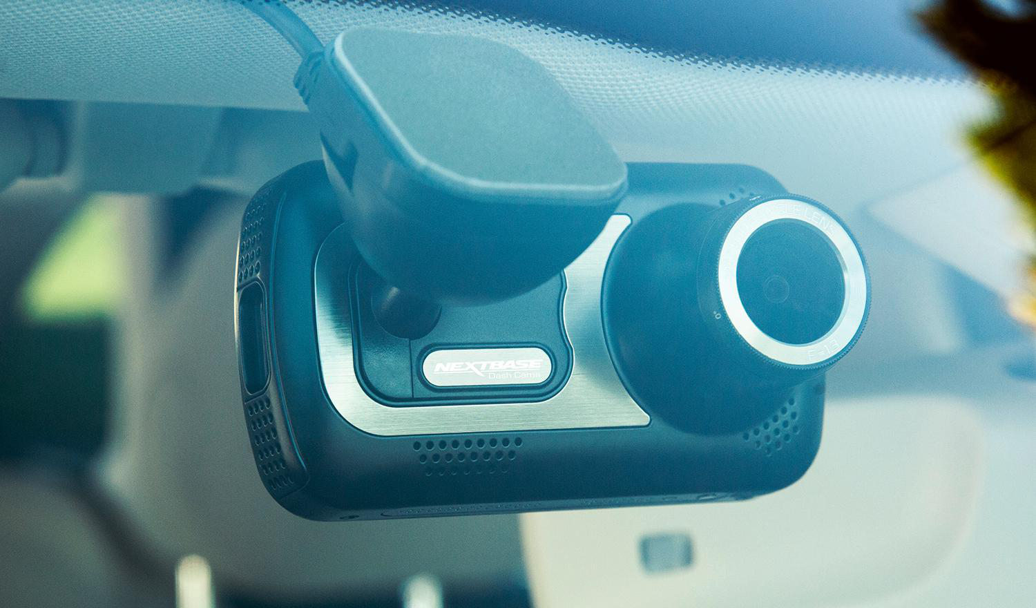 Am der Windschutzscheibe montierte Dashcam mit Linse und Nextbase-Logo.