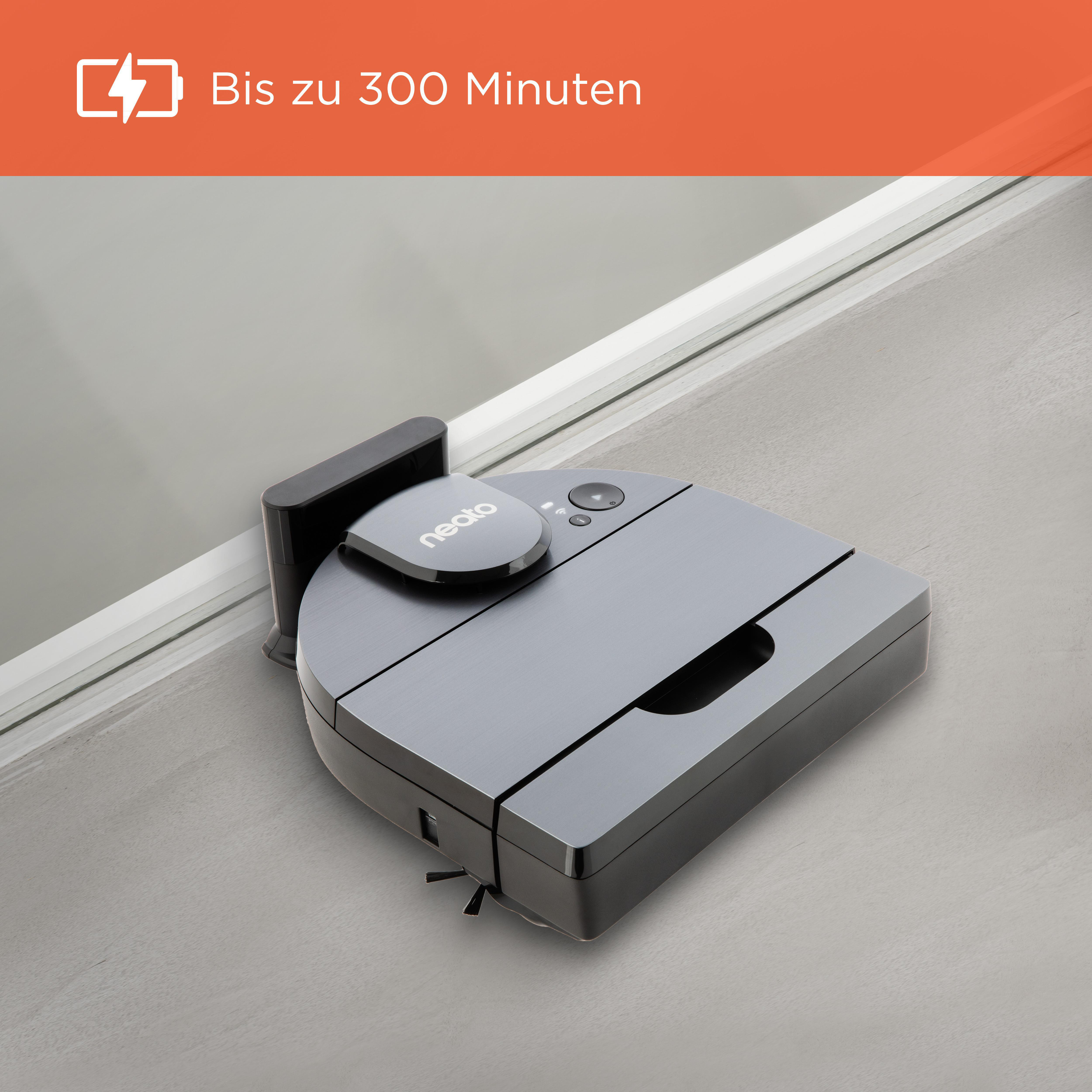 Ein Roboter-Staubsauger auf einem grauen Boden. Er hat eine Ladestation daneben.