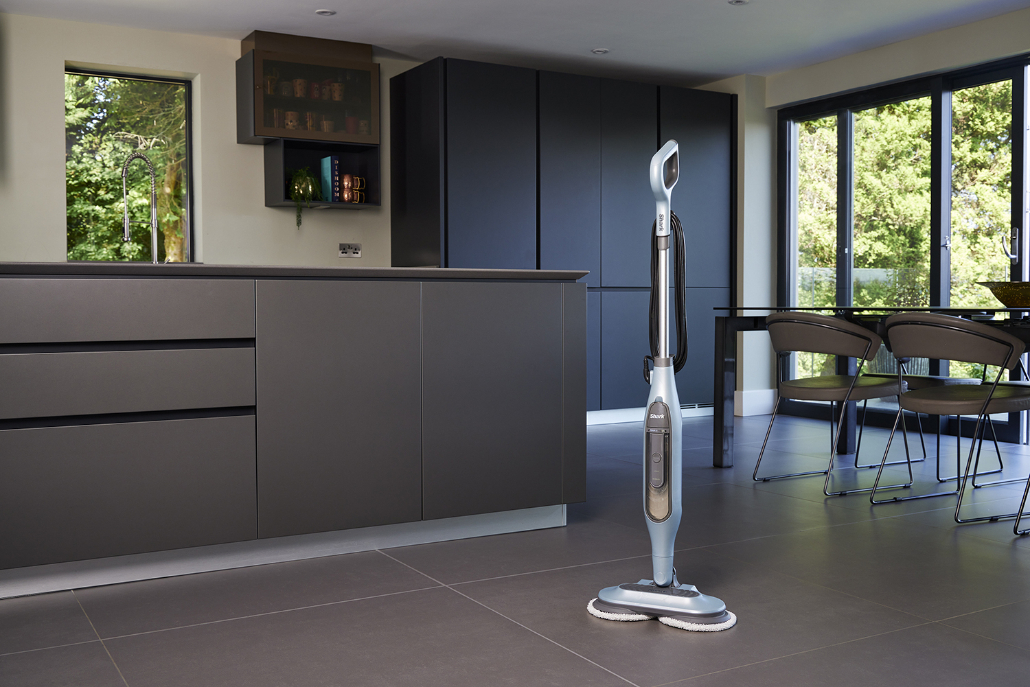 Een stoommop in een moderne keuken. Donkere kasten en ramen op de achtergrond.