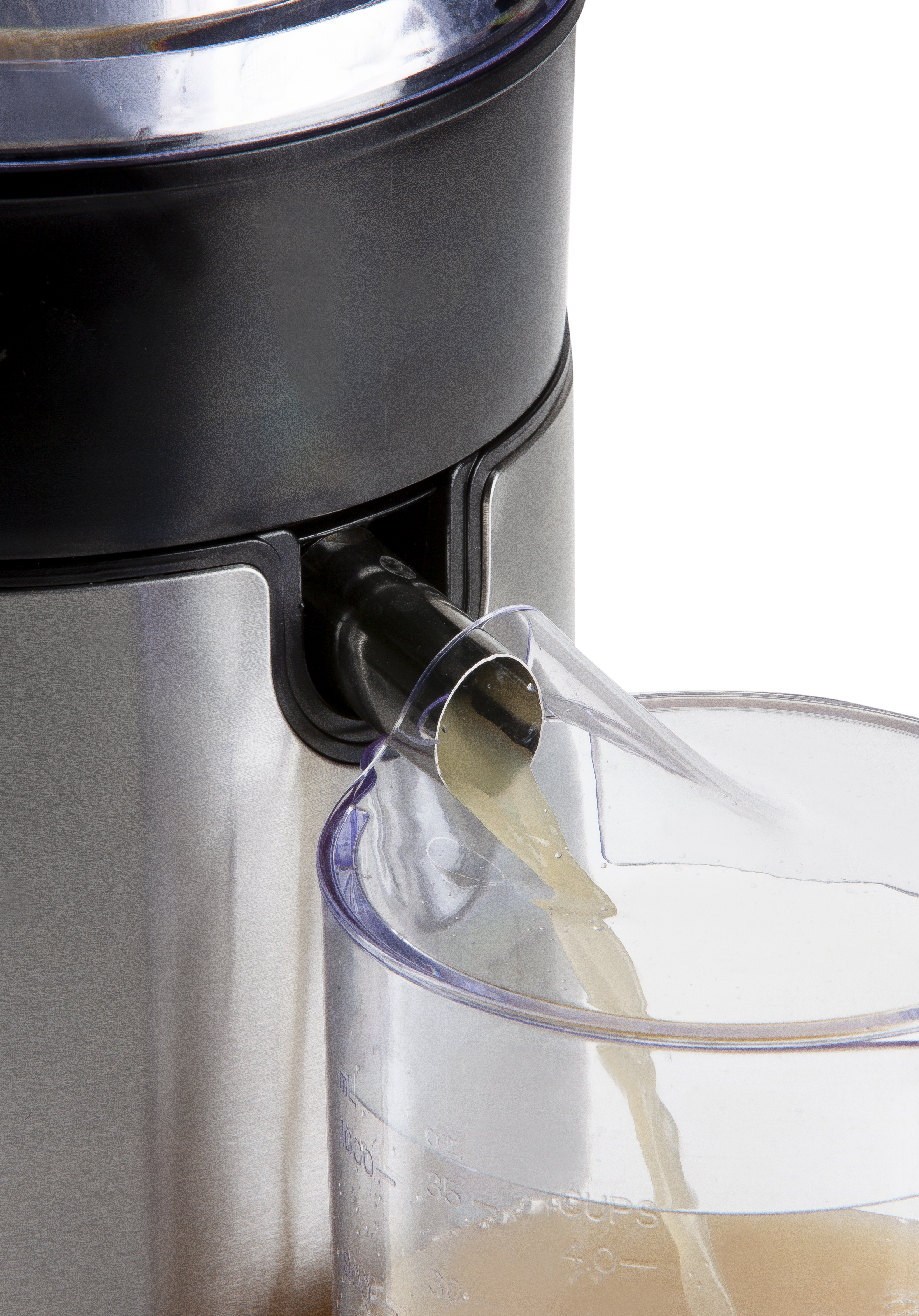 A juicer in action, with juice flowing into a clear pitcher. Stainless steel and black accents.