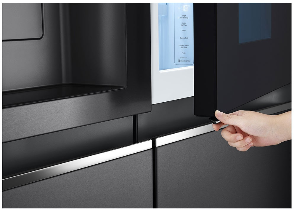 Main ouvrant une porte de réfrigérateur noire avec écran tactile.